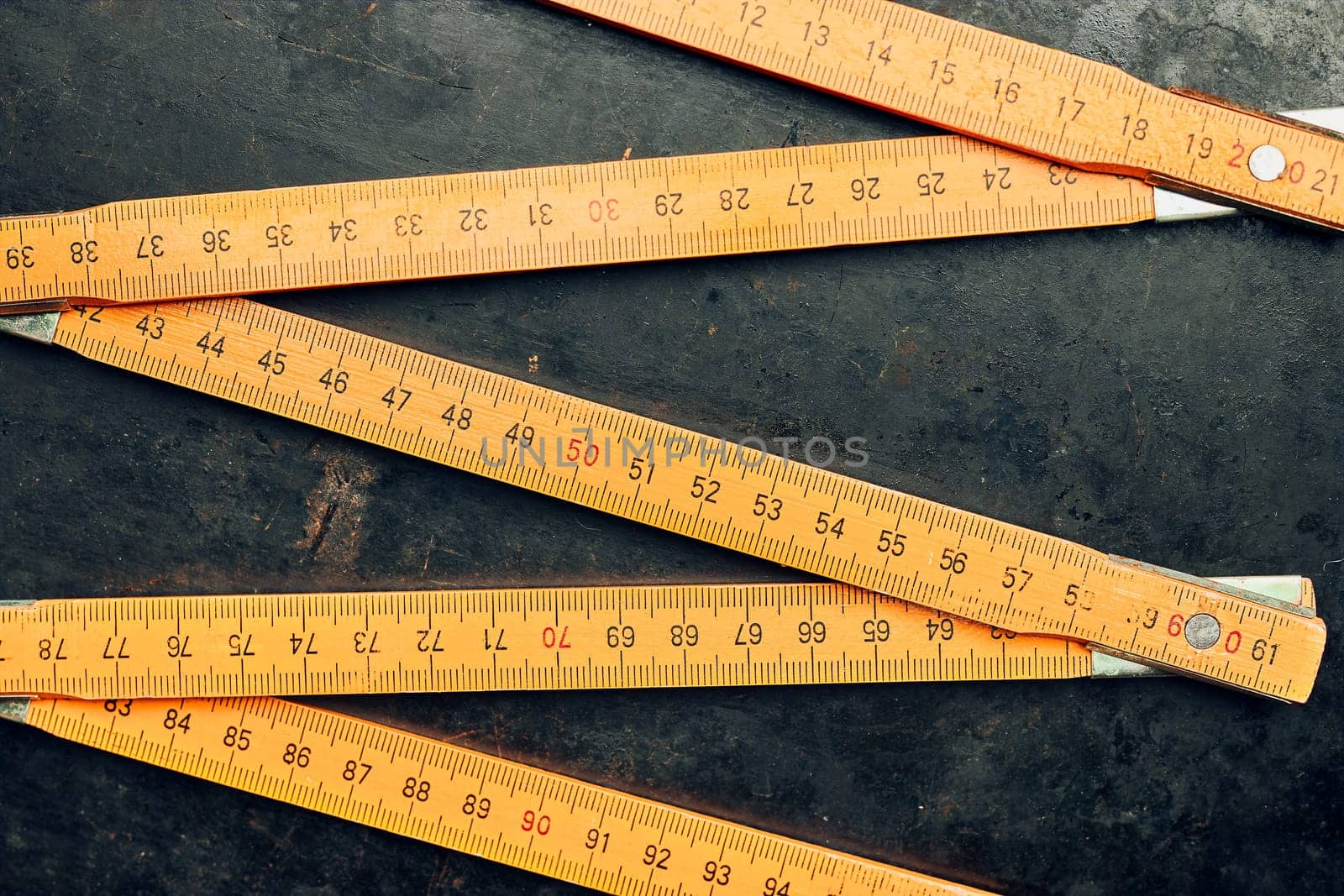 Wooden measure. Old ruler on metal surface. Measuring tool. Technical background with copy space