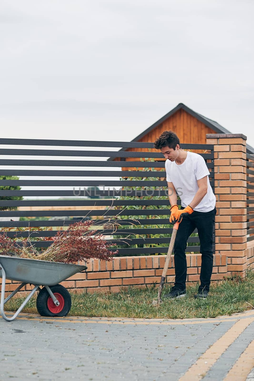 Teenage boy planting the plants, working at a home garden. Candid people, real moments, authentic situations