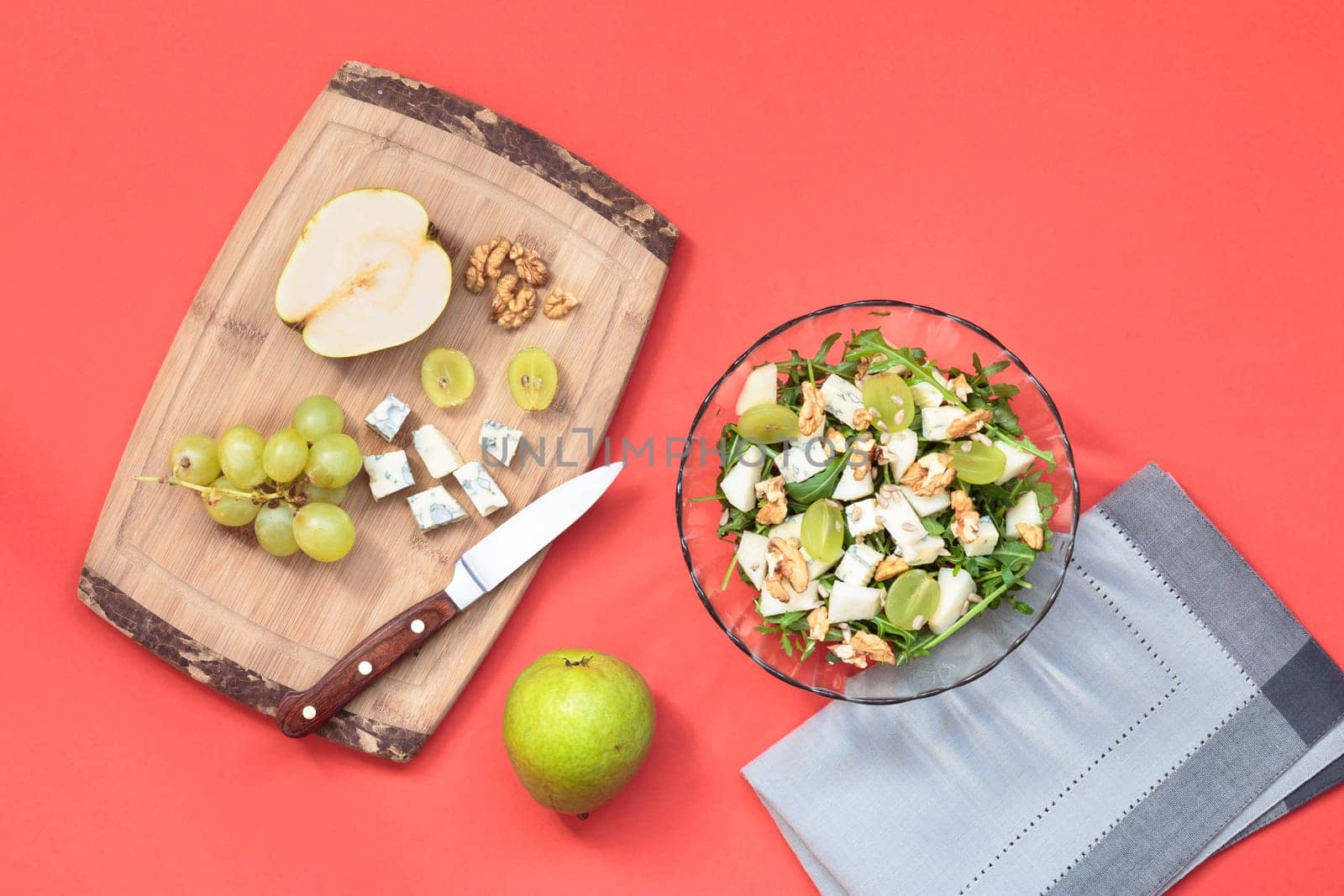Making salad with grapes, pear, walnut and blue cheese