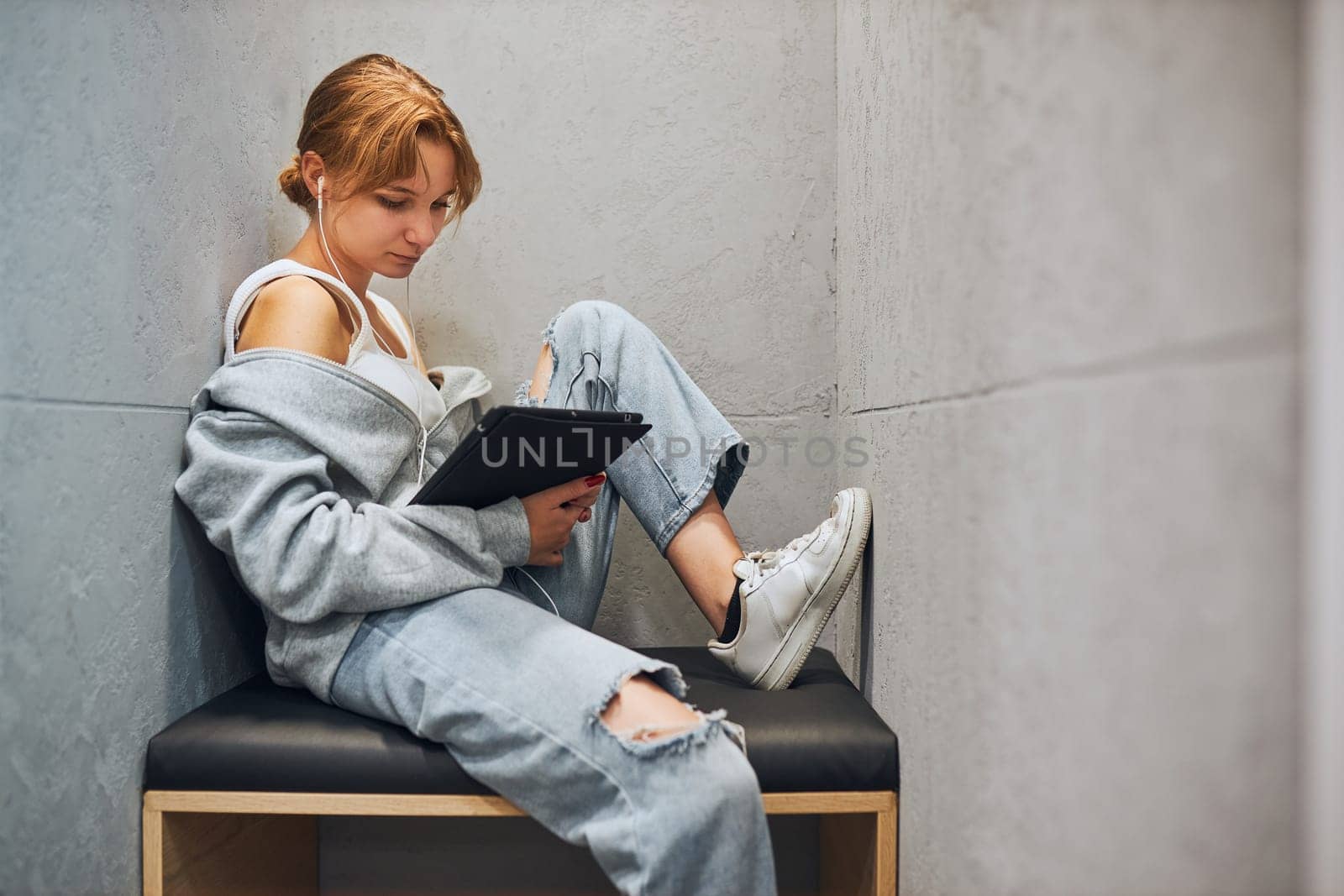 Student learning in university library. Young woman reading e-book using computer tablet. Focused student studying for college exams. Using technology