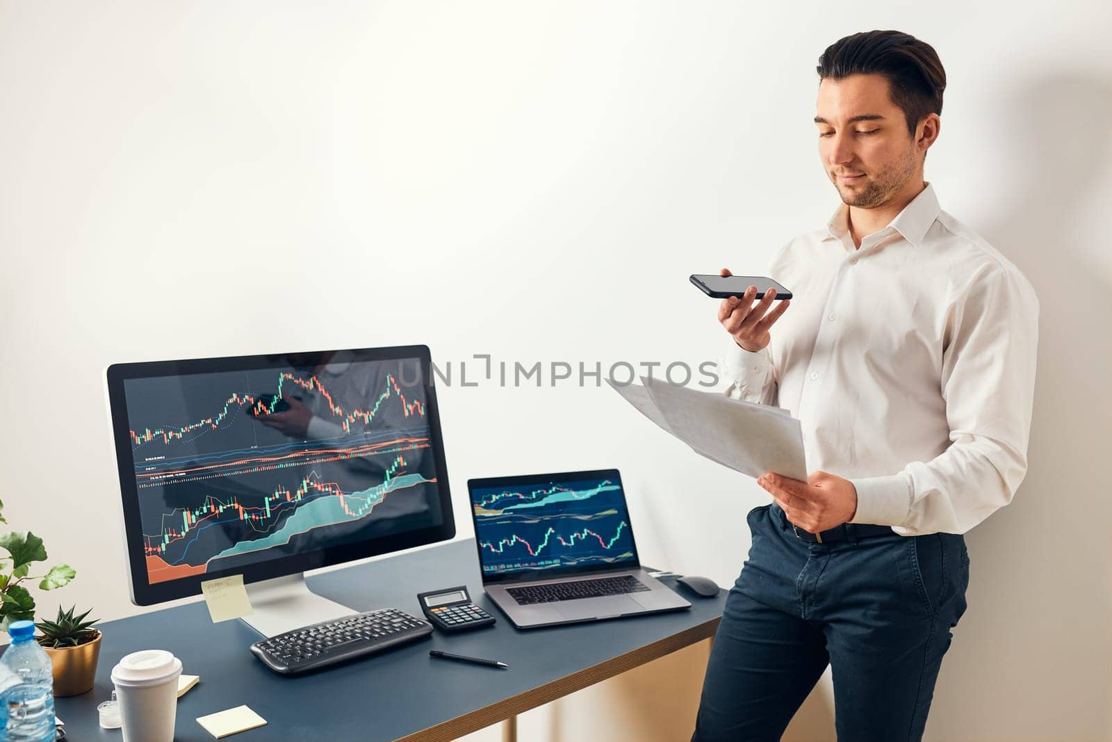 Businessman trading stocks online. Stock investor discussing numbers at graphs while phone conversation with his colleague. Business team planning and analyzing stock market graphs. Man working with stock chart data. Business man investing stock using online platform. Business success concept