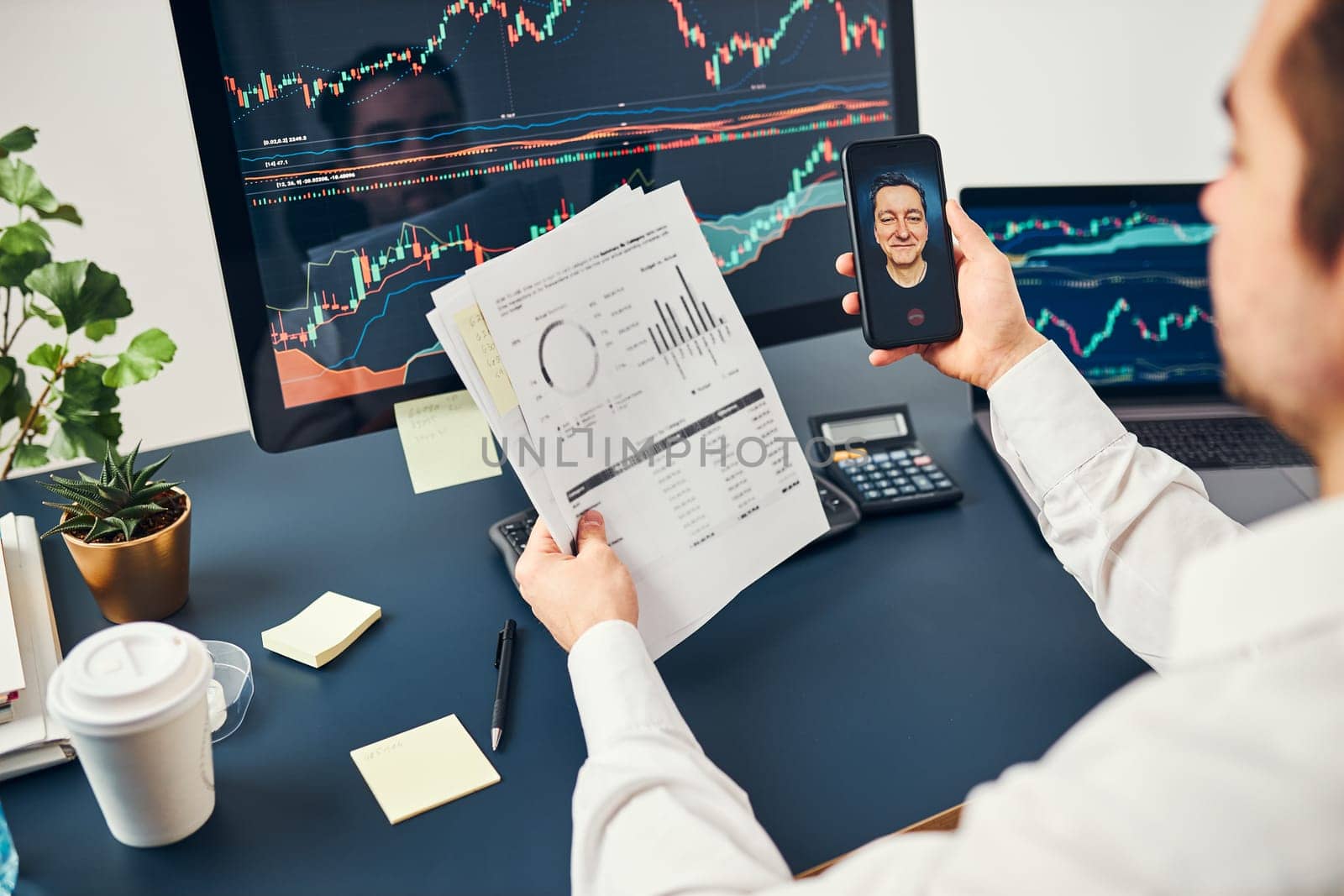Businessman trading stocks online. Stock investor discussing numbers at graphs while video conversation with his colleague. Business team planning and analyzing stock market graphs. Man working with stock chart data. Business man investing stock using online platform. Business success concept