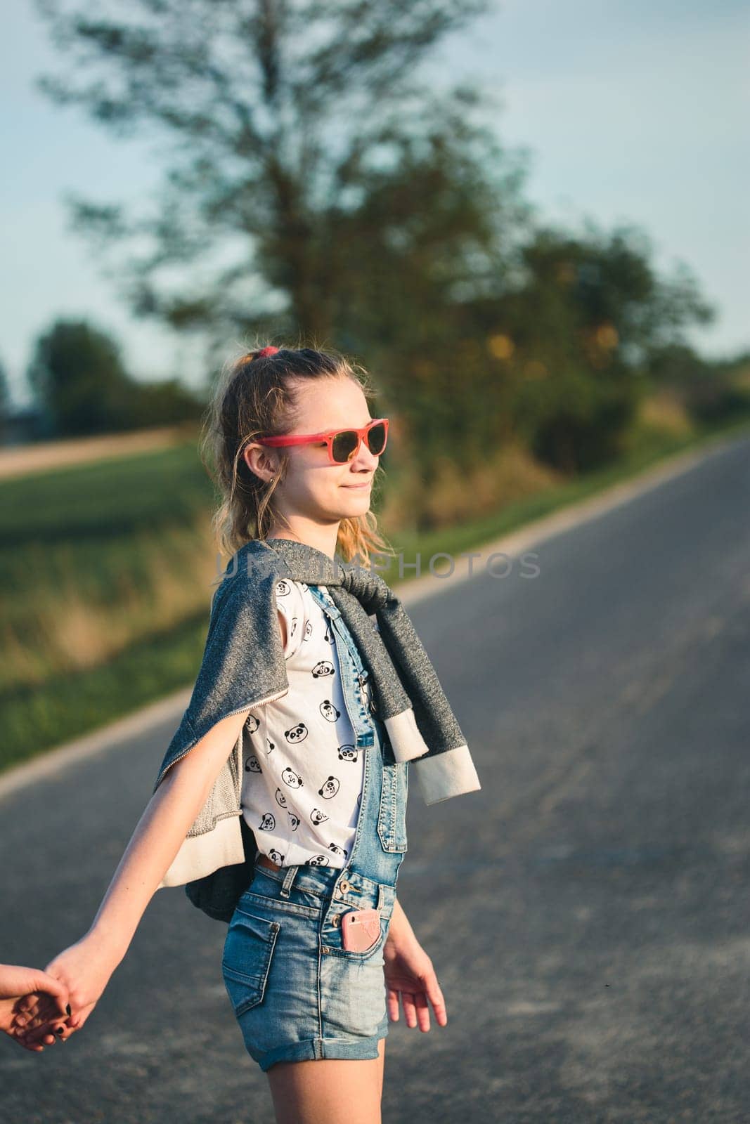 Teenage smiling happy girls having fun walking outdoors, hanging, spending time together on summer day