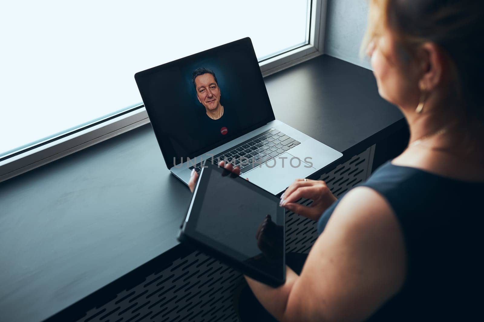 Businesswoman having business video call on laptop in office. Mature busy woman remotely working from office. Female manager using digital devices. Remote communication. Video calling. Remote work