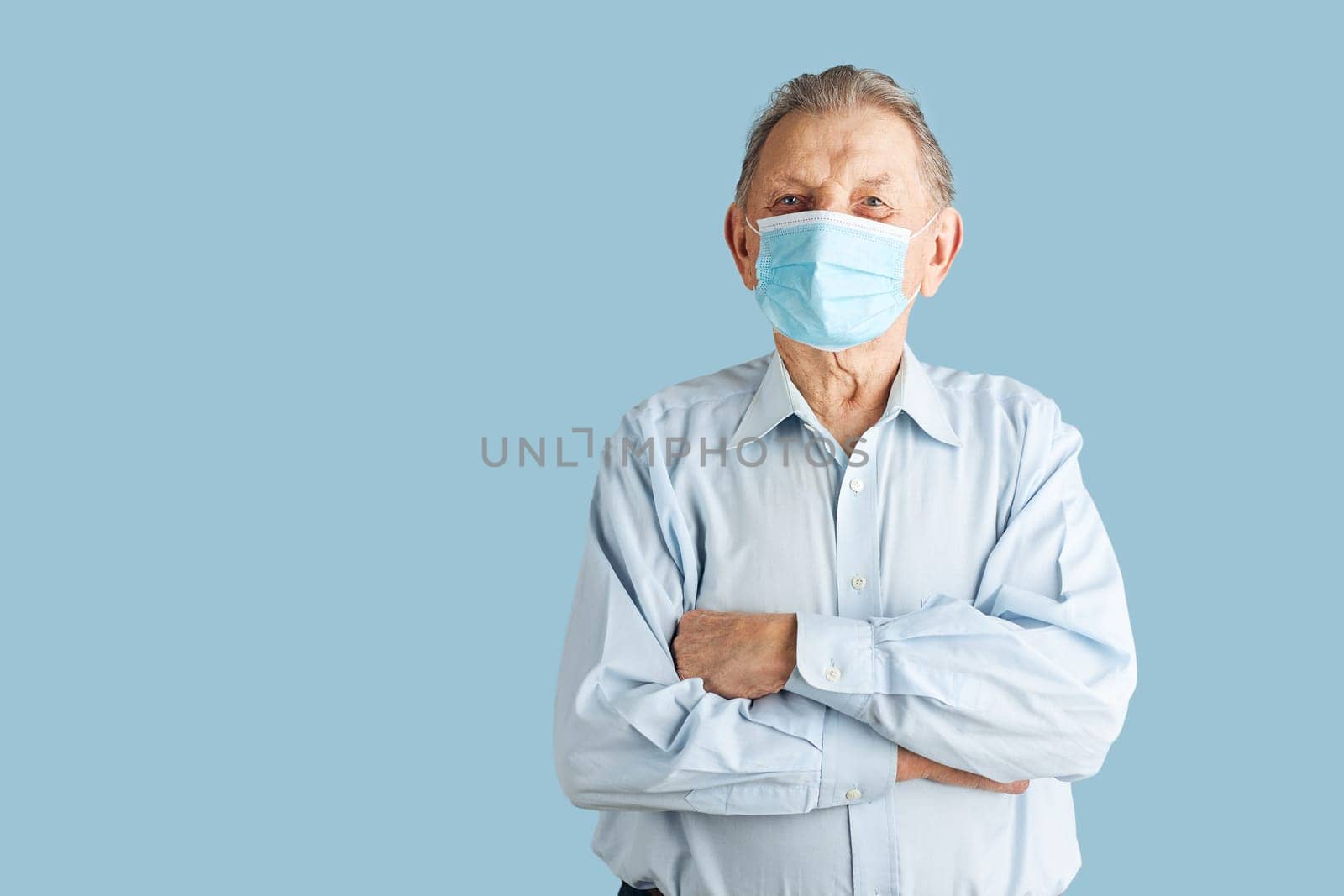 Old aged senior male patient with face mask. Wearing coronavirus covid-19 protection medical mask during the pandemic