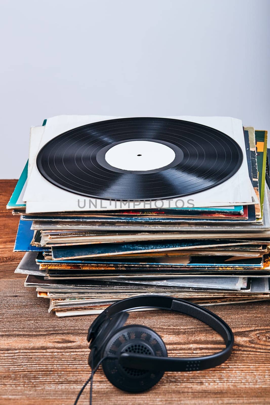 Stack of black vinyl records and headphones on the top. Candid people, real moments, authentic situations