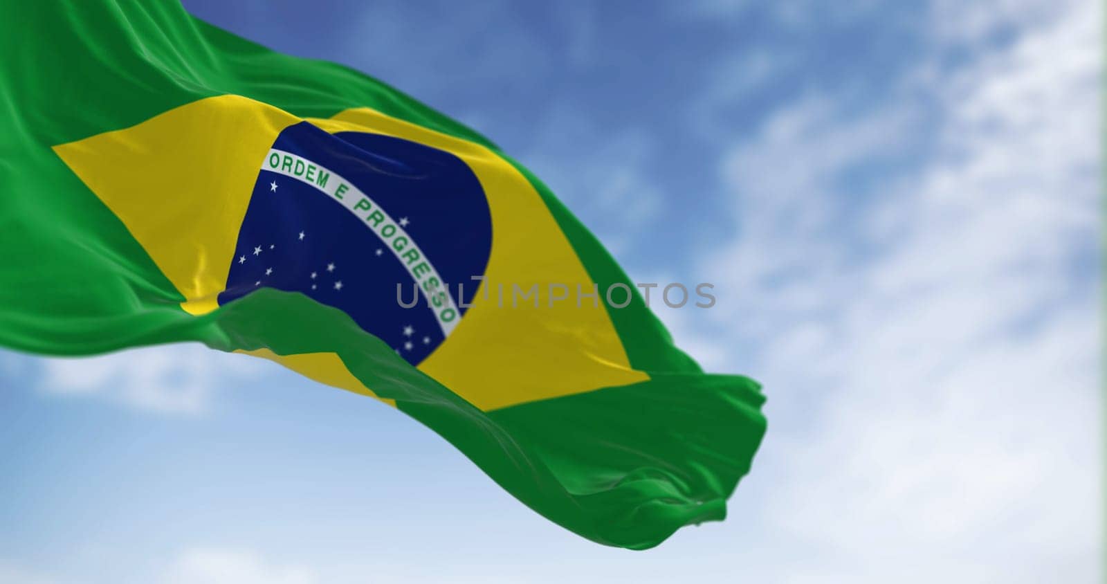 Brazil national flag waving on a clear day. Yellow diamond on green field with blue circle of 27 white, five-pointed stars. South American country. 3d illustration render. Fluttering fabric.