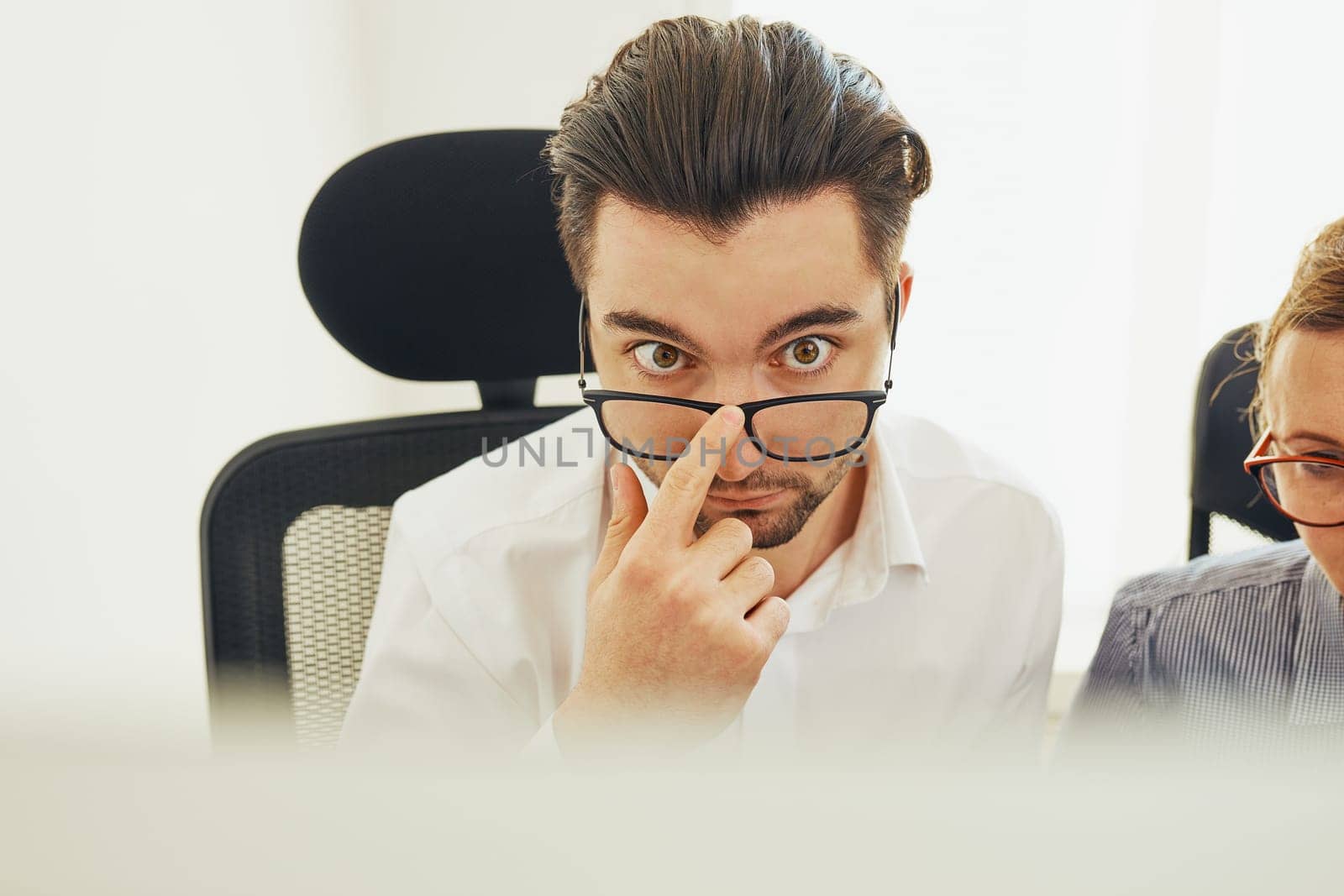 Two business people discussing financial data looking at computer screen. Entrepreneurs working hard sitting at computere screen in office. People having deadline working together. Workmates talking about project