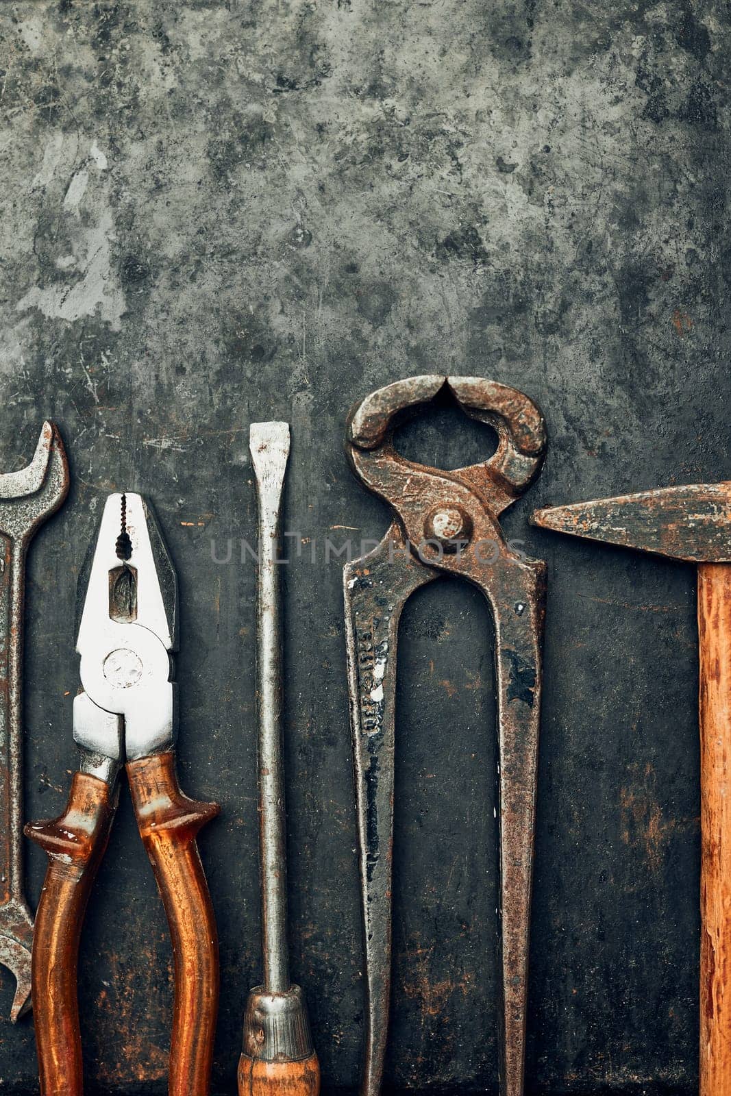 Old hardware tools. Wrench, screwdriver, measure, hammer, pliers on steel surface. Mechanic tools for maintenance. Hardware tools to fix. Technical background with copy space