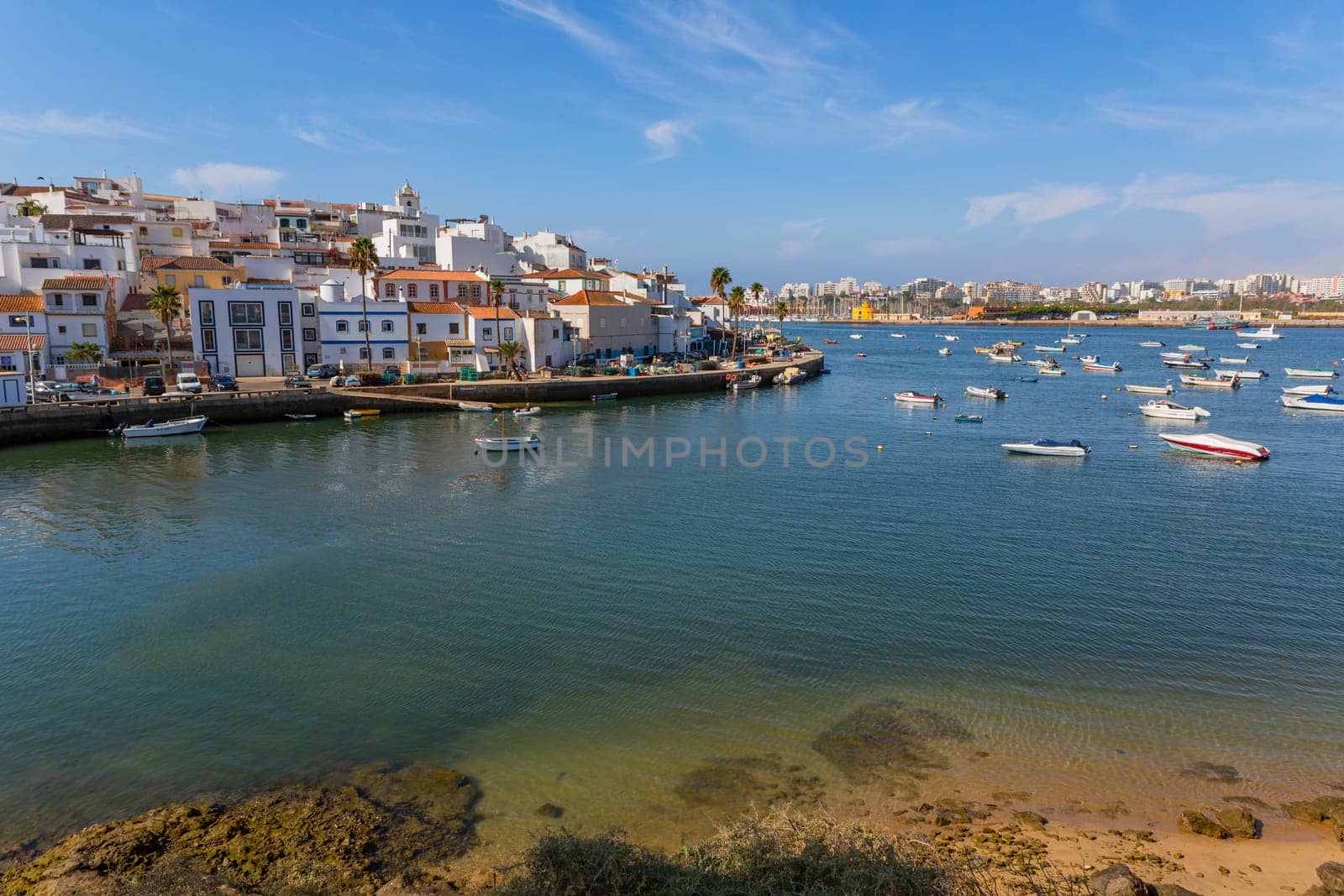 Ferragudo, Portugal - August 25, 2022 - View of the white town with boats moored in the foreground, Ferragudo, Algarve, Portugal, Europe