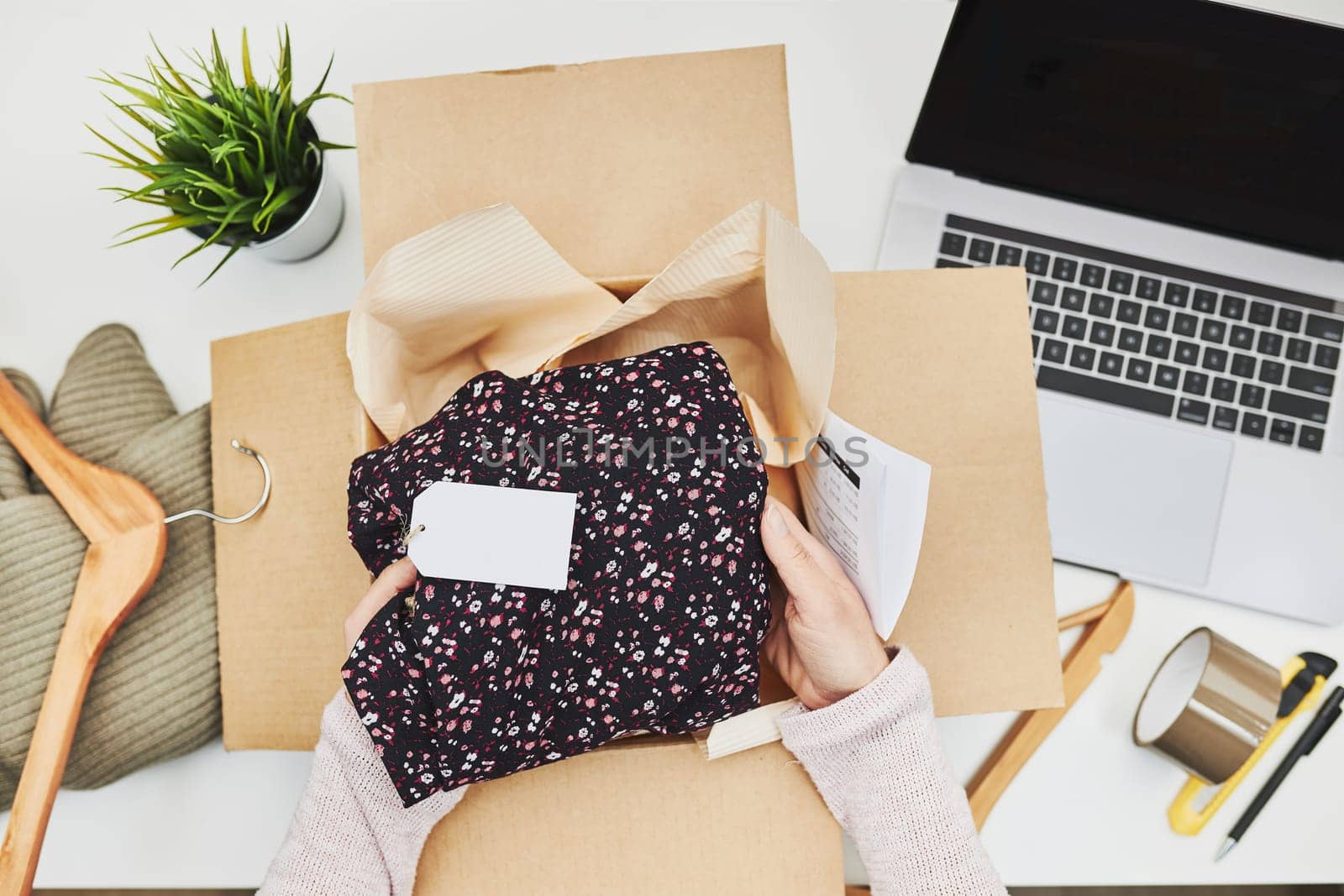 Business owner packing online order to delivery to customer. Preparing parcel box with clothes product from online shop