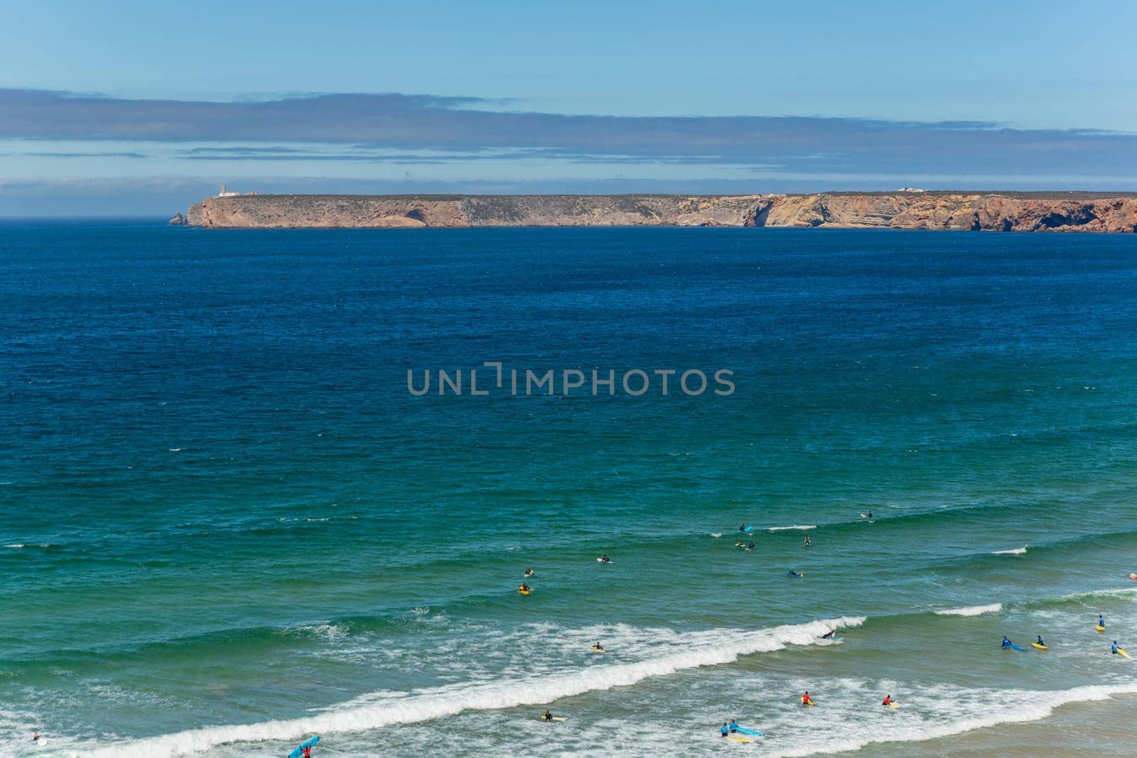 Sagres, Portugal - August 25, 2022: View of surfers on sandy beach near Sagres village in Algarve, Portugal