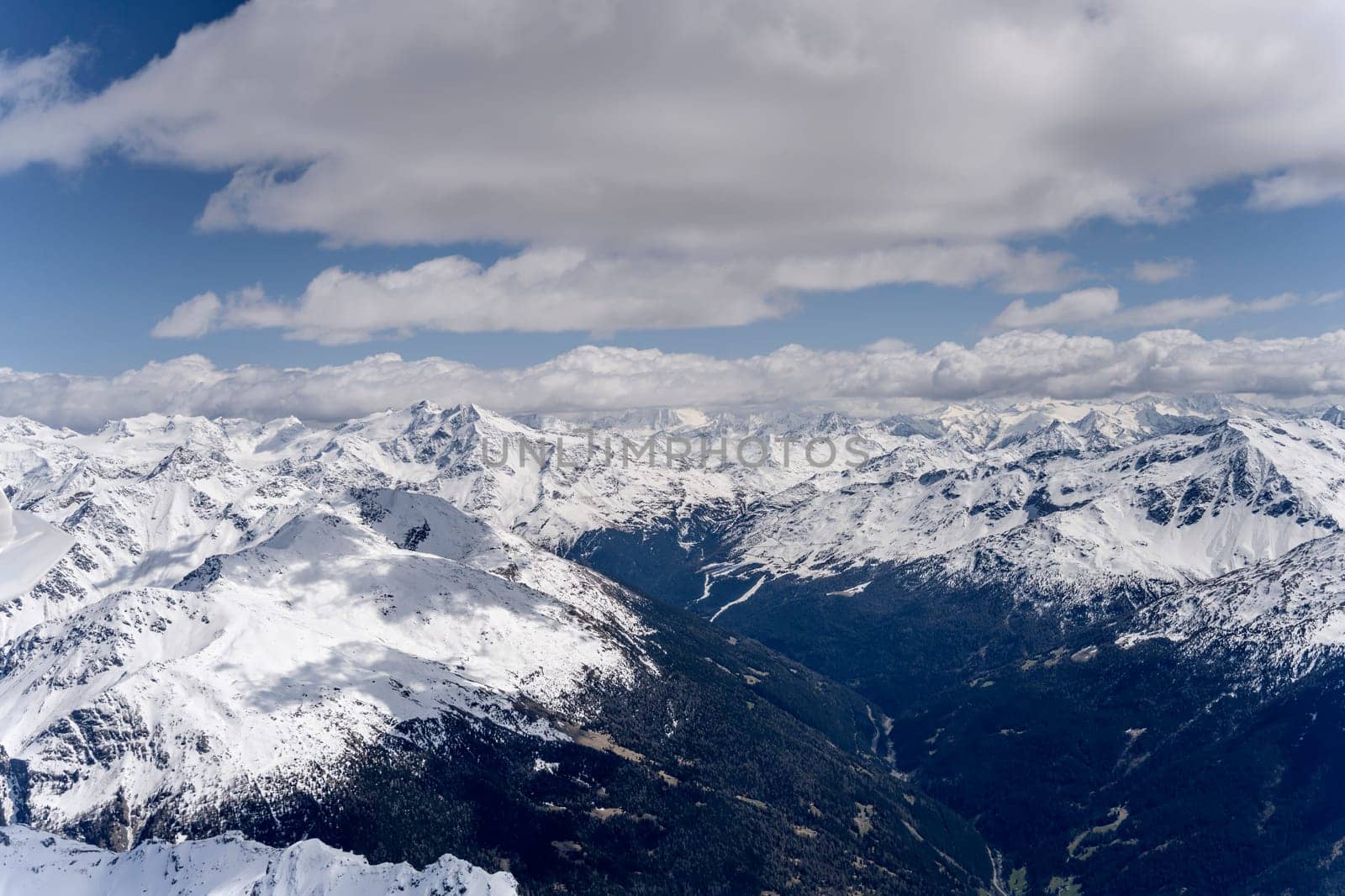aerial landscape, from a glider plane, of Valfurva valley and Confinale peak and surrounding ranges under recent sping snow, shot from north in bright late spring light, Sondrio, Italy