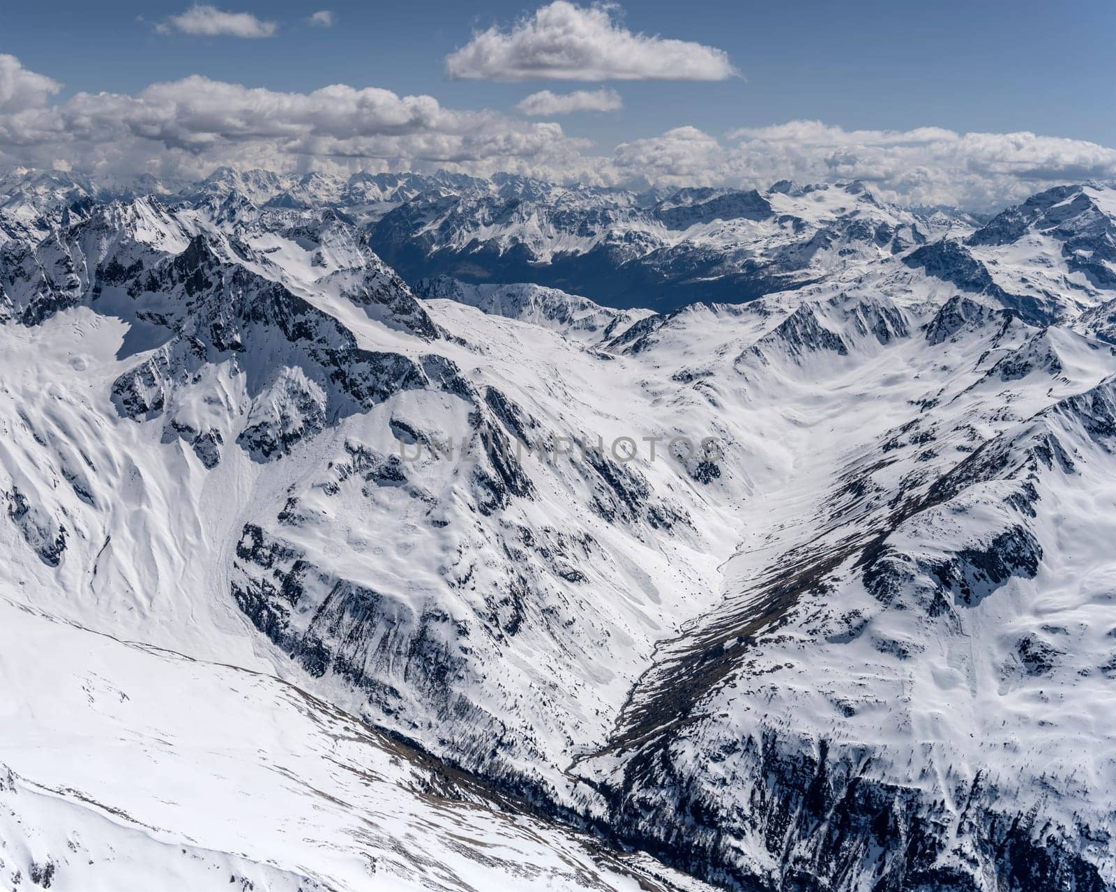 aerial landscape, from a glider plane, of Campo valley and peak, shot from west in bright late spring light, Poschiavo, Switzerland
