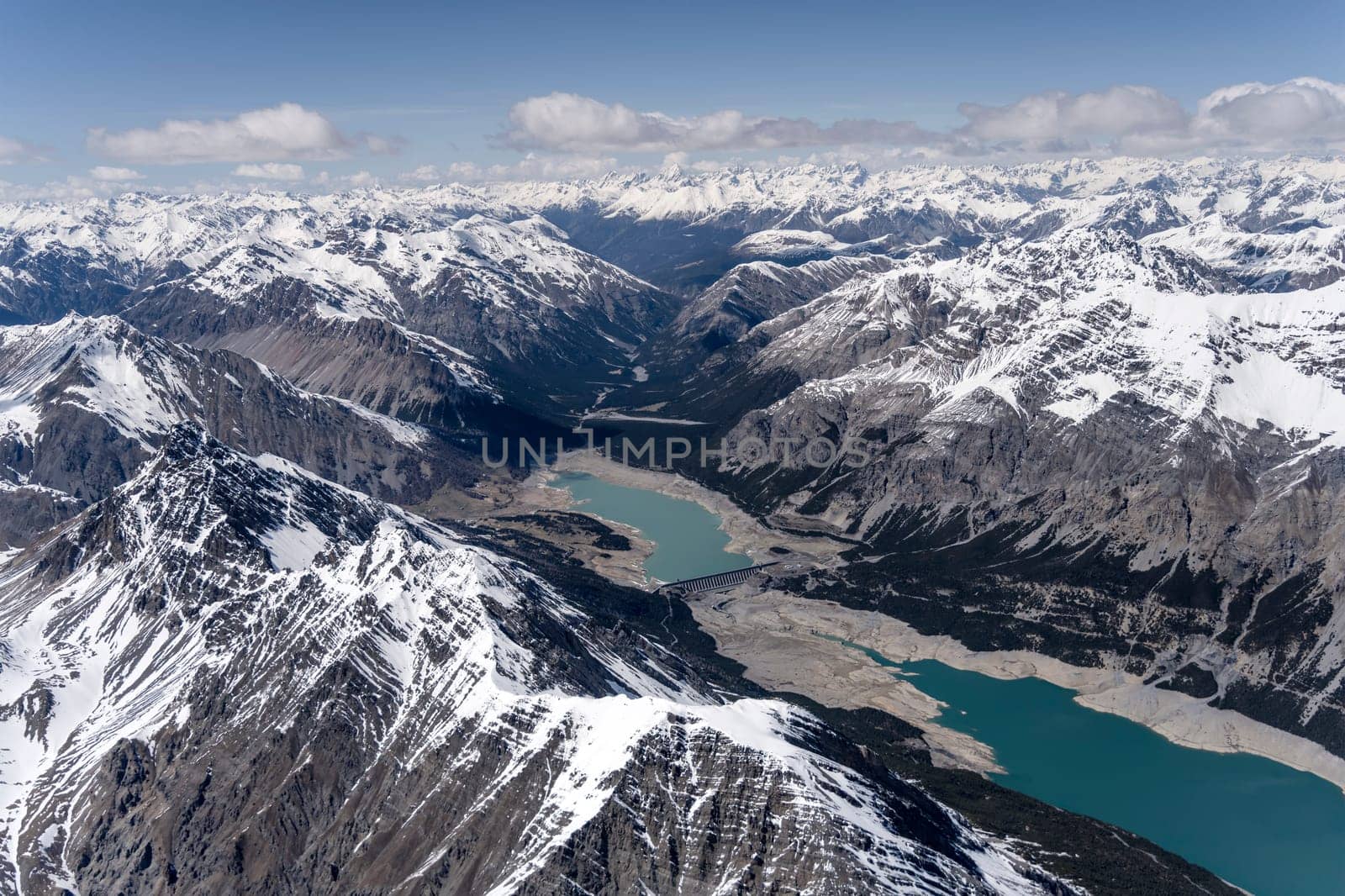 aerial landscape, from a glider plane, of S.Giacomo lake with Valbruna valley in background, shot from south west in bright late spring light, Sondrio, Italy