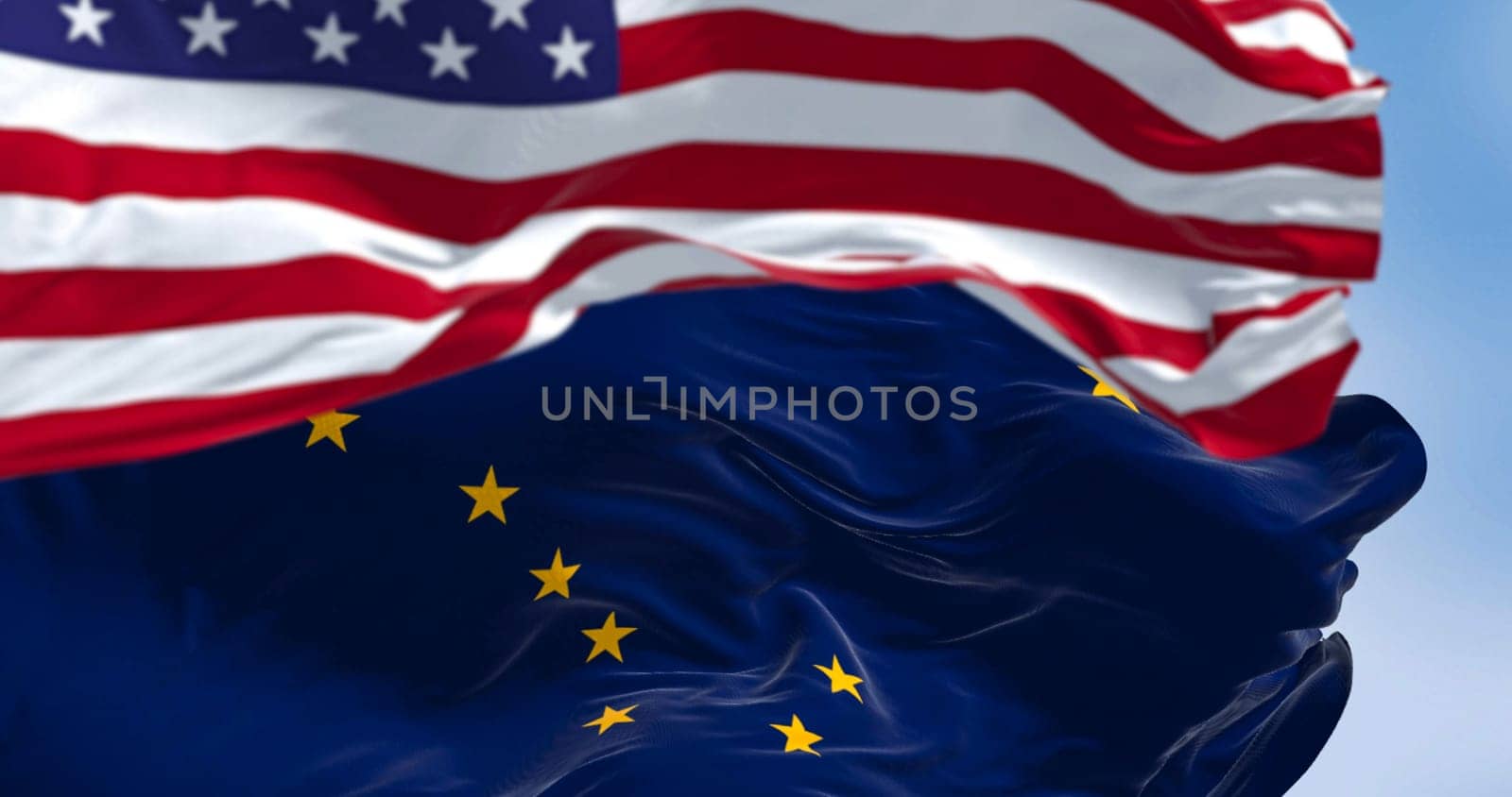 Alaska state flag waving in the wind behind the national flag of the United States. Alaska flag is blue with Big Dipper and Polaris stars. 3d illustration render. Rippled fabric. Selective focus