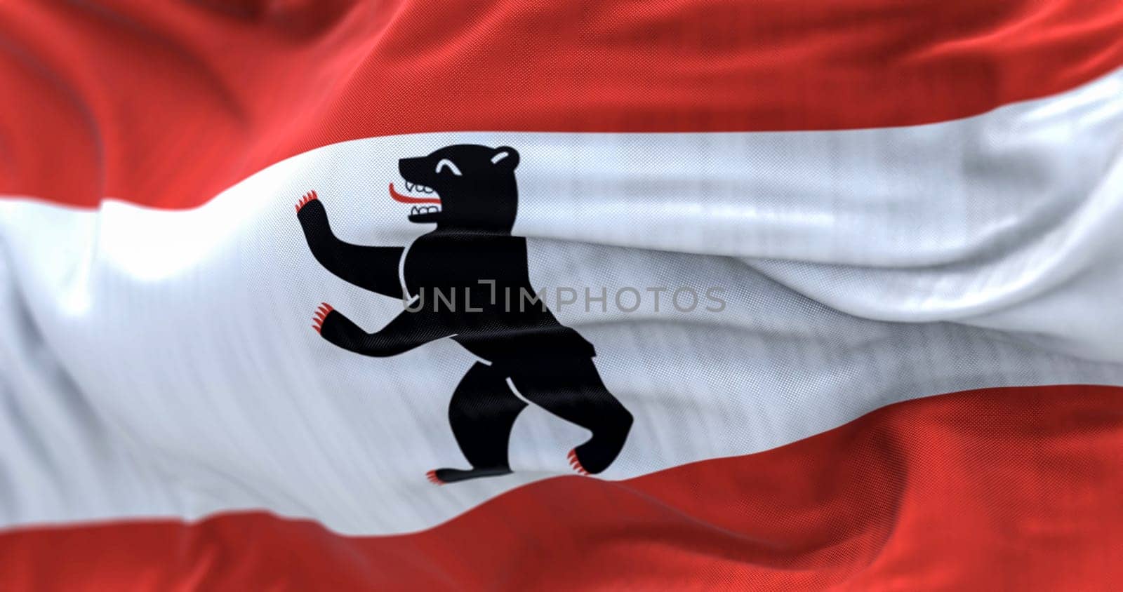 Berlin civil flag waving in the wind. Three stripes of red-white-red with a bear on the center. 3d illustration render. Selective focus. Fluttering fabric. Close-up