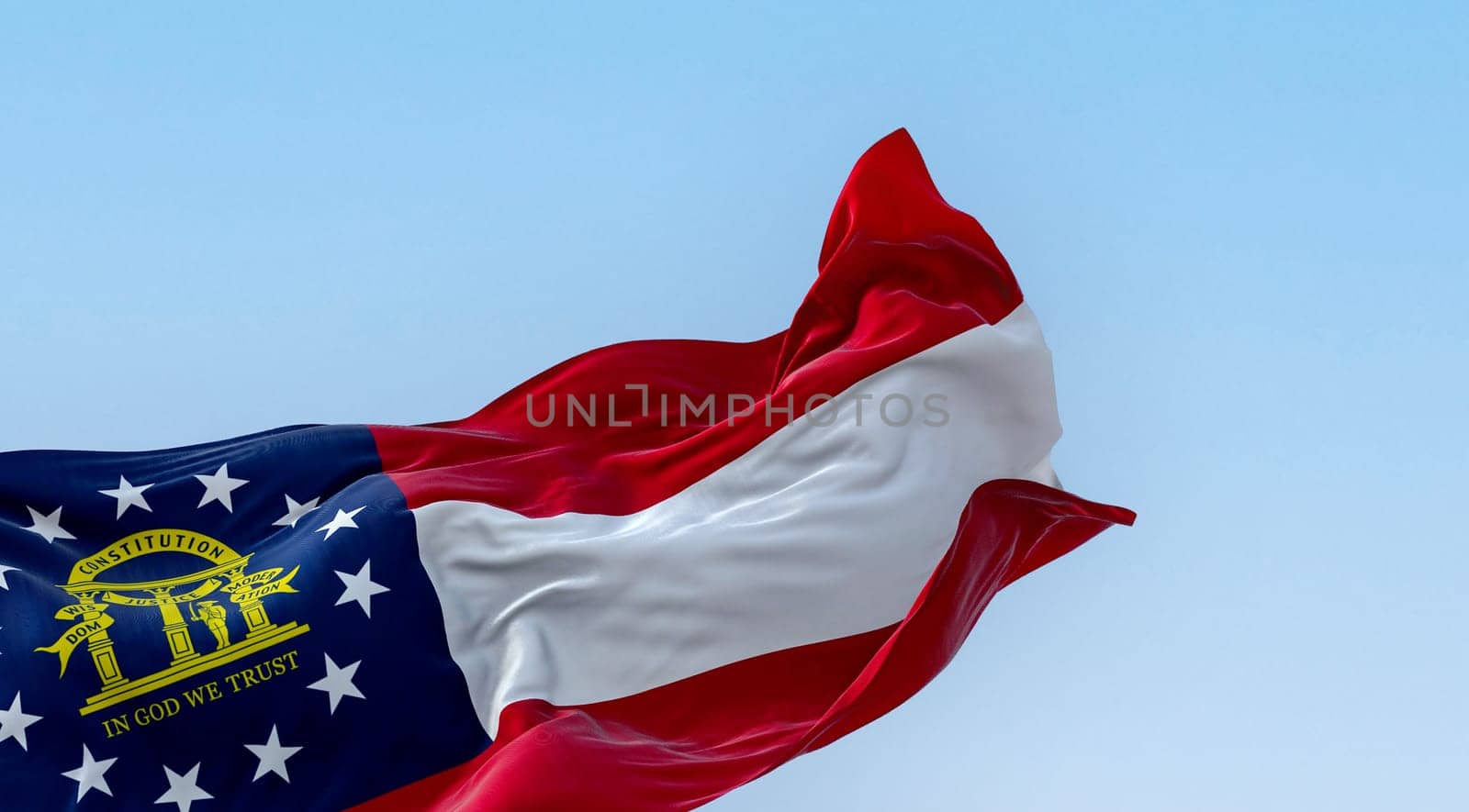 The state flag of Georgia waving in the wind on a clear day. Red, white, red stripes. Blue canton with 13 stars and coat of arms. 3d illustration render. Fluttering textile