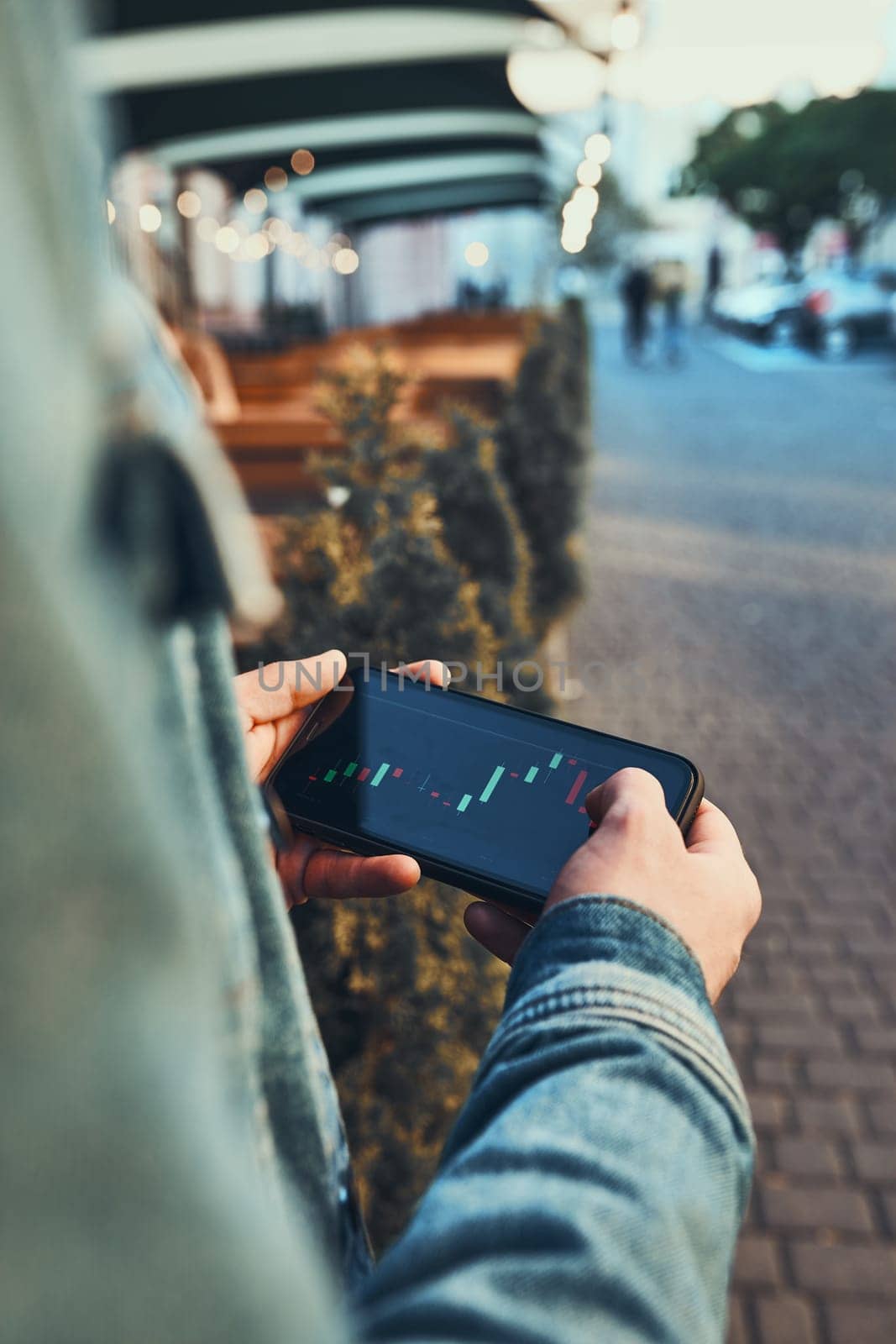 Person investing trading on stock cryptocurrency market using investing application on smartphone. Stock market investment in hand. Trader holding mobile phone looking at candle chart