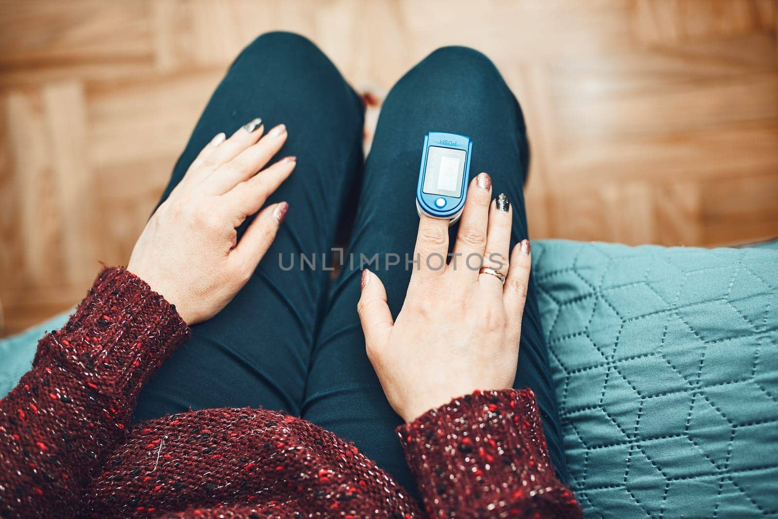 Woman measuring the degree of oxygen saturation of the blood and heart rate at home using pulse oximeter. Home treatment of virus. Checking health condition. Coronavirus pandemic. Covid-19 outbreak