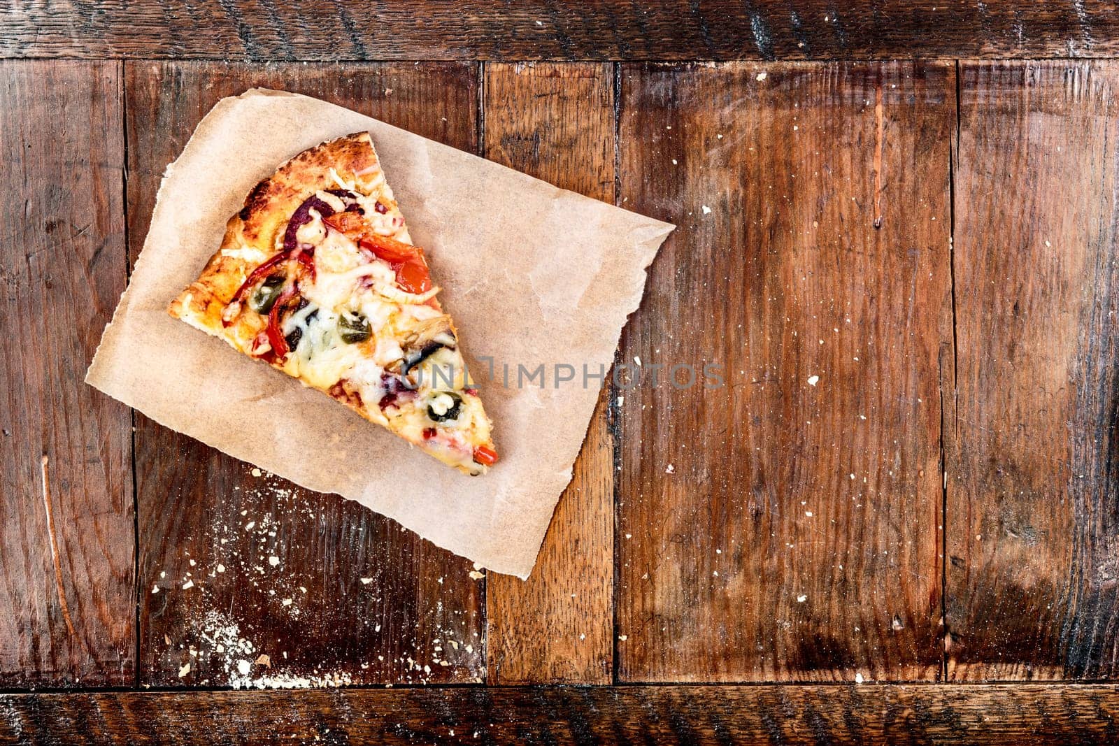 Piece of pizza on wooden table. Copy space on the right. View from above