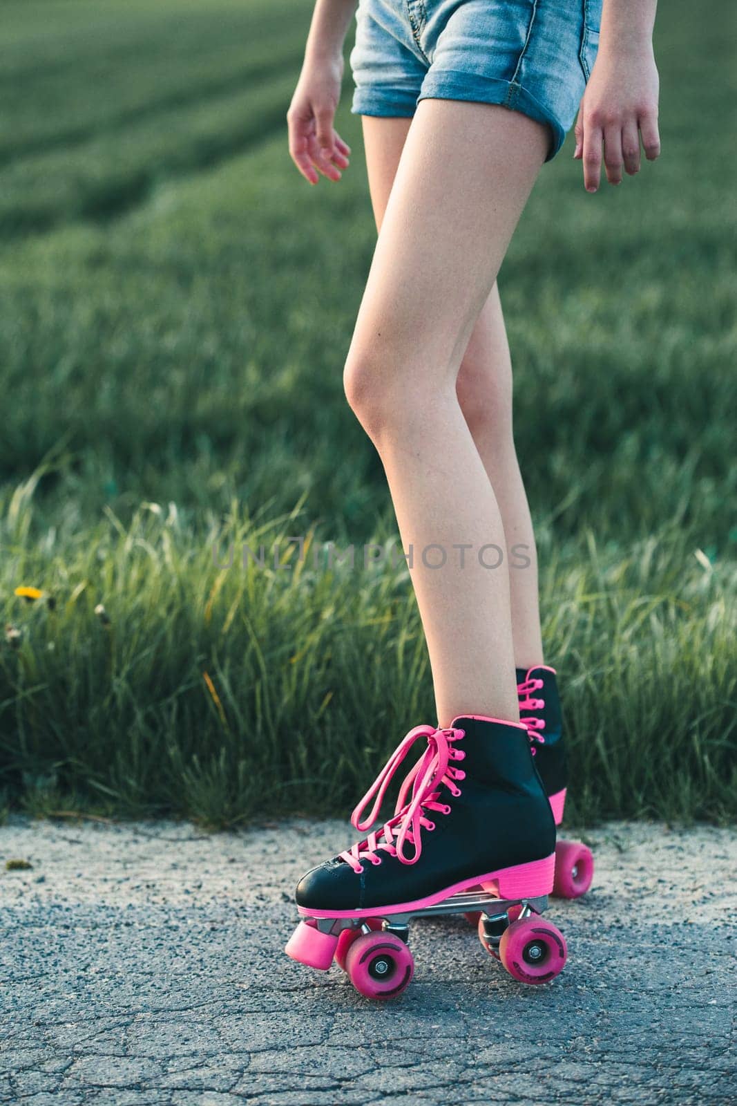 Teenage girl having fun rollerskating, jumping, spending time on summer day