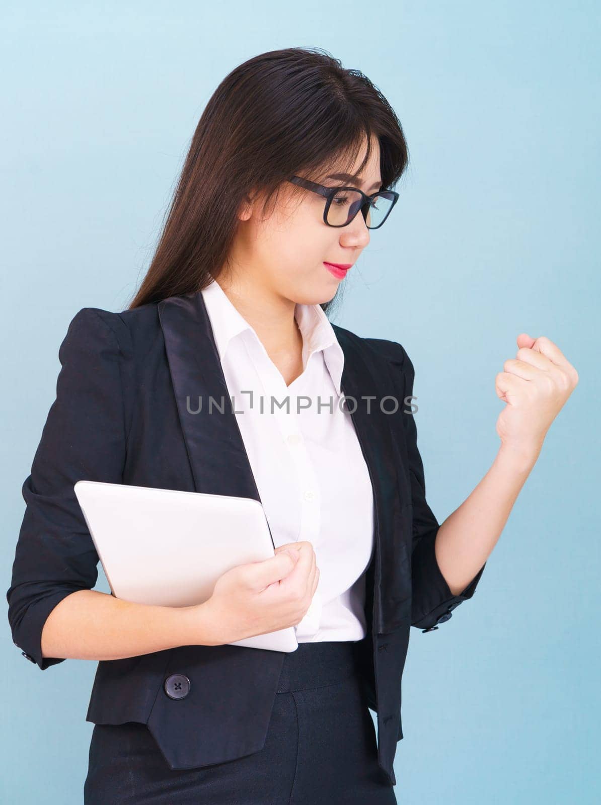 Young women standing in suit holding her digital tablet computor with finger pointing up