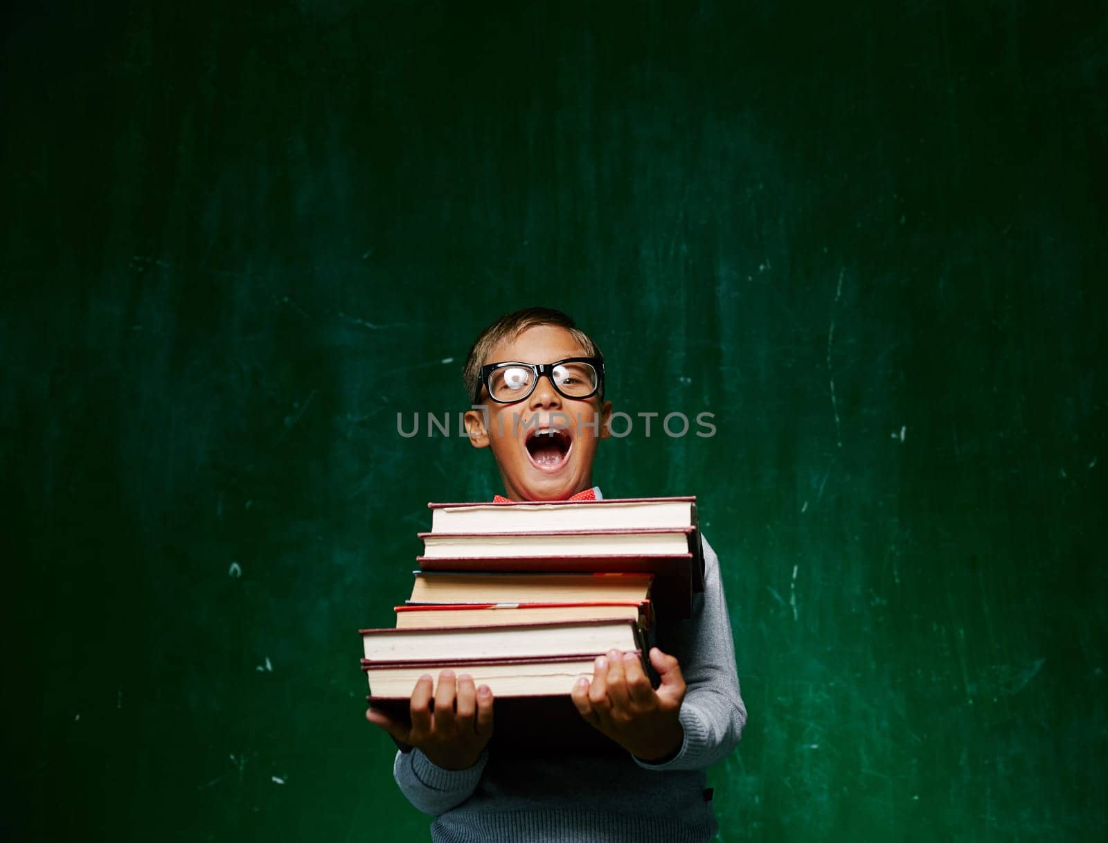 Ecstatic schoolboy in eyeglasses holding books