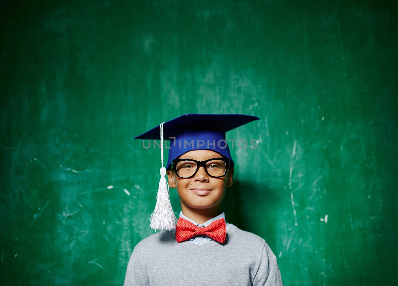 Smiling kid in eyeglasses and graduation hat