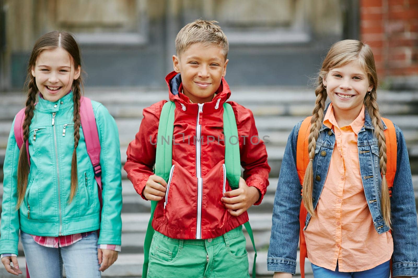 Group of cute schoolmates with backpacks looking at camera