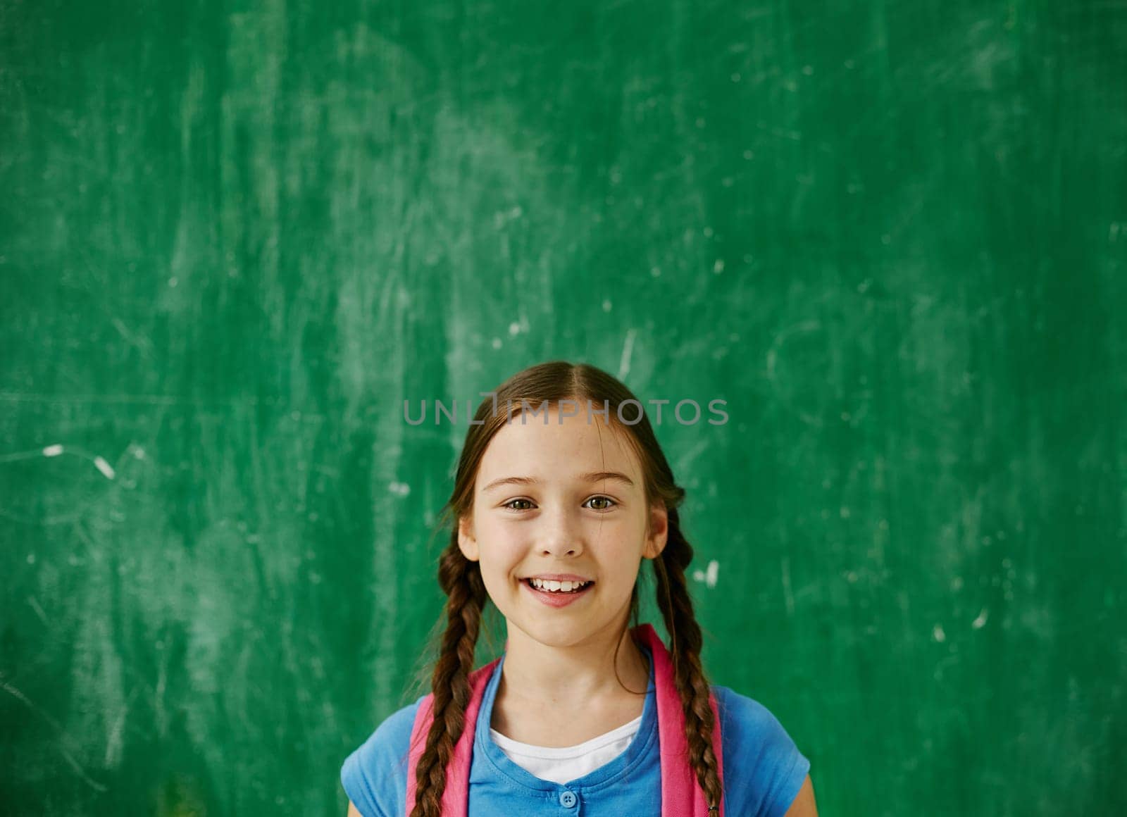 Cute youngster with backpack looking at camera with smile