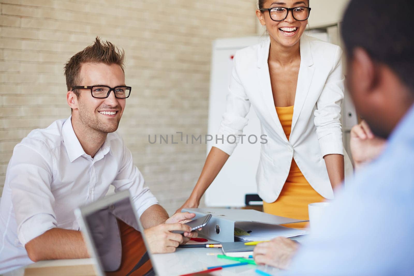 Smiling business partners talking to colleagues at meeting