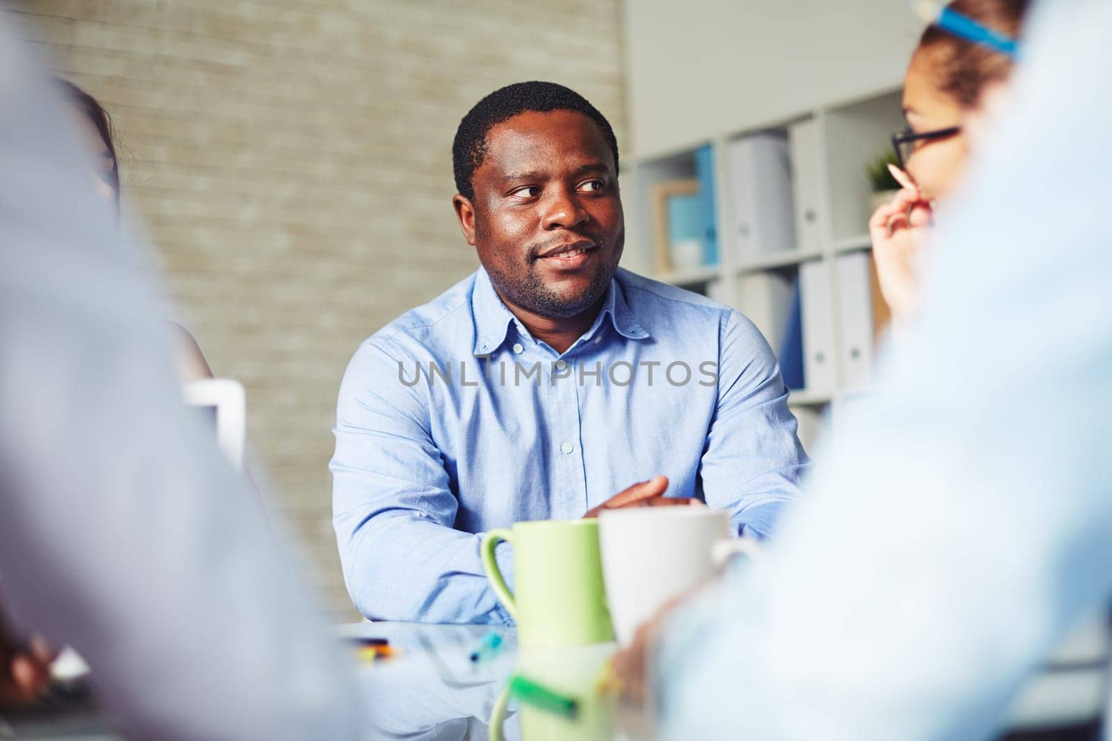 African-american businessman looking at colleague at meeting