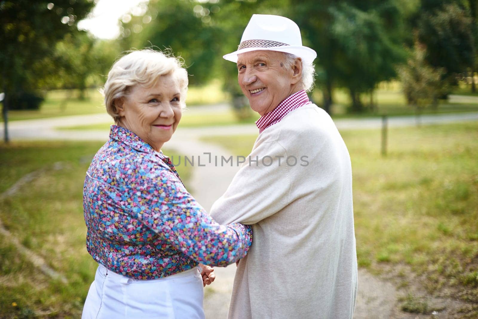 Happy senior couple looking at camera during walk