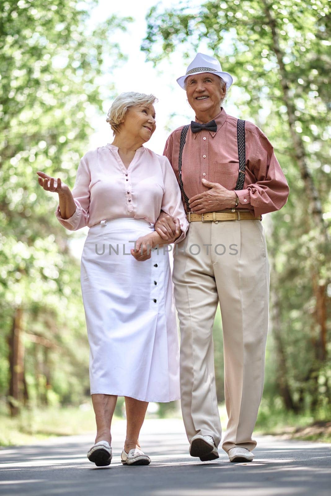 Affectionate seniors chilling out in park in summer