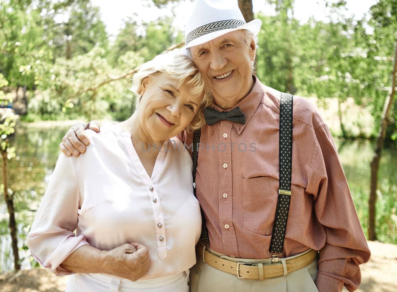 Cheerful senior couple looking at camera with smiles