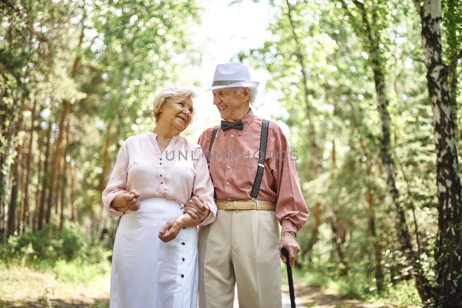Affectionate seniors in smart casual talking while chilling out in park