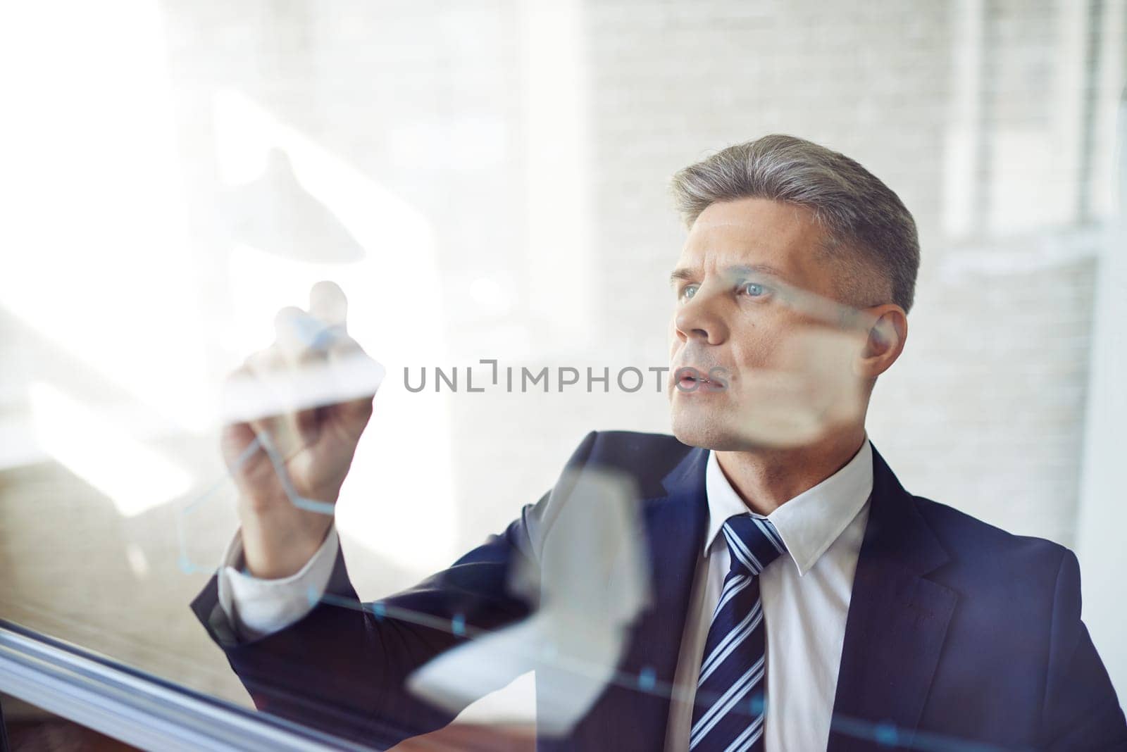 Modern businessman standing by transparent board