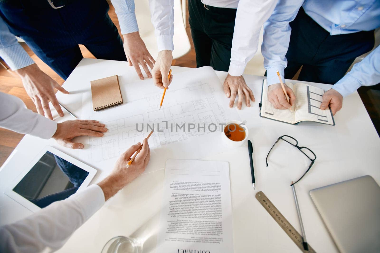 Group of architects discussing sketch of construction by desk