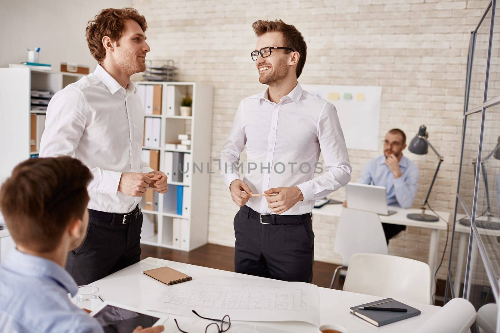 Happy architects sharing their ideas in working environment