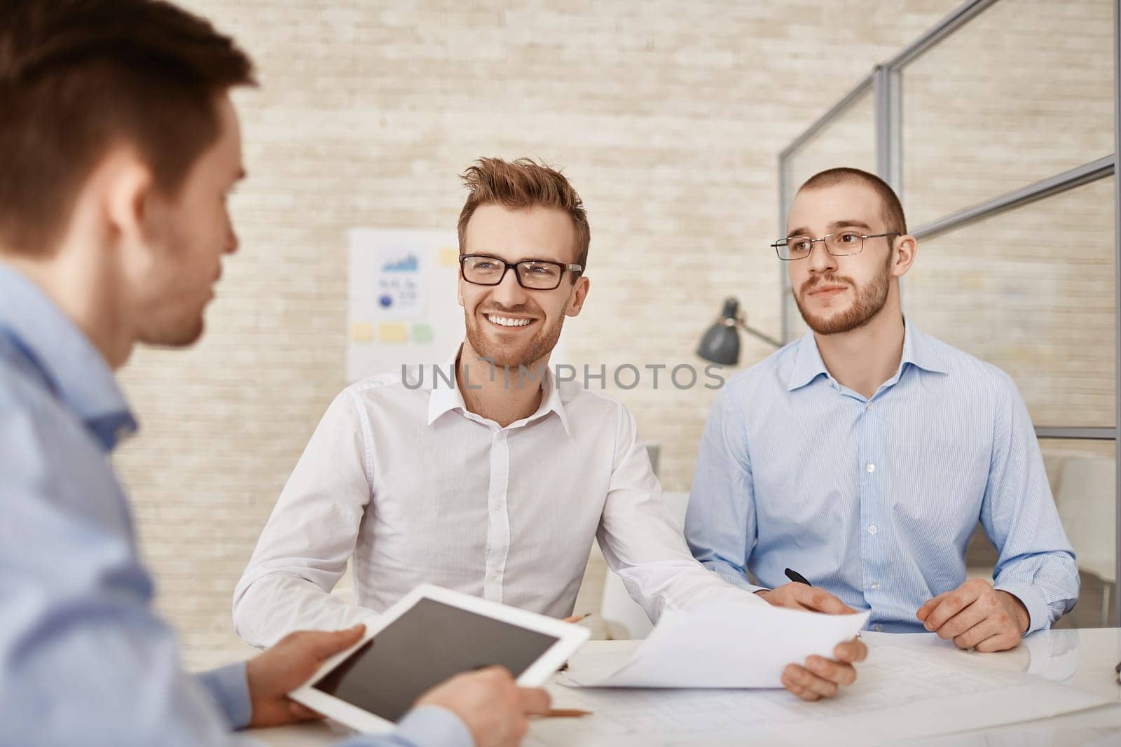 Three businessmen discussing plans and strategies at meeting
