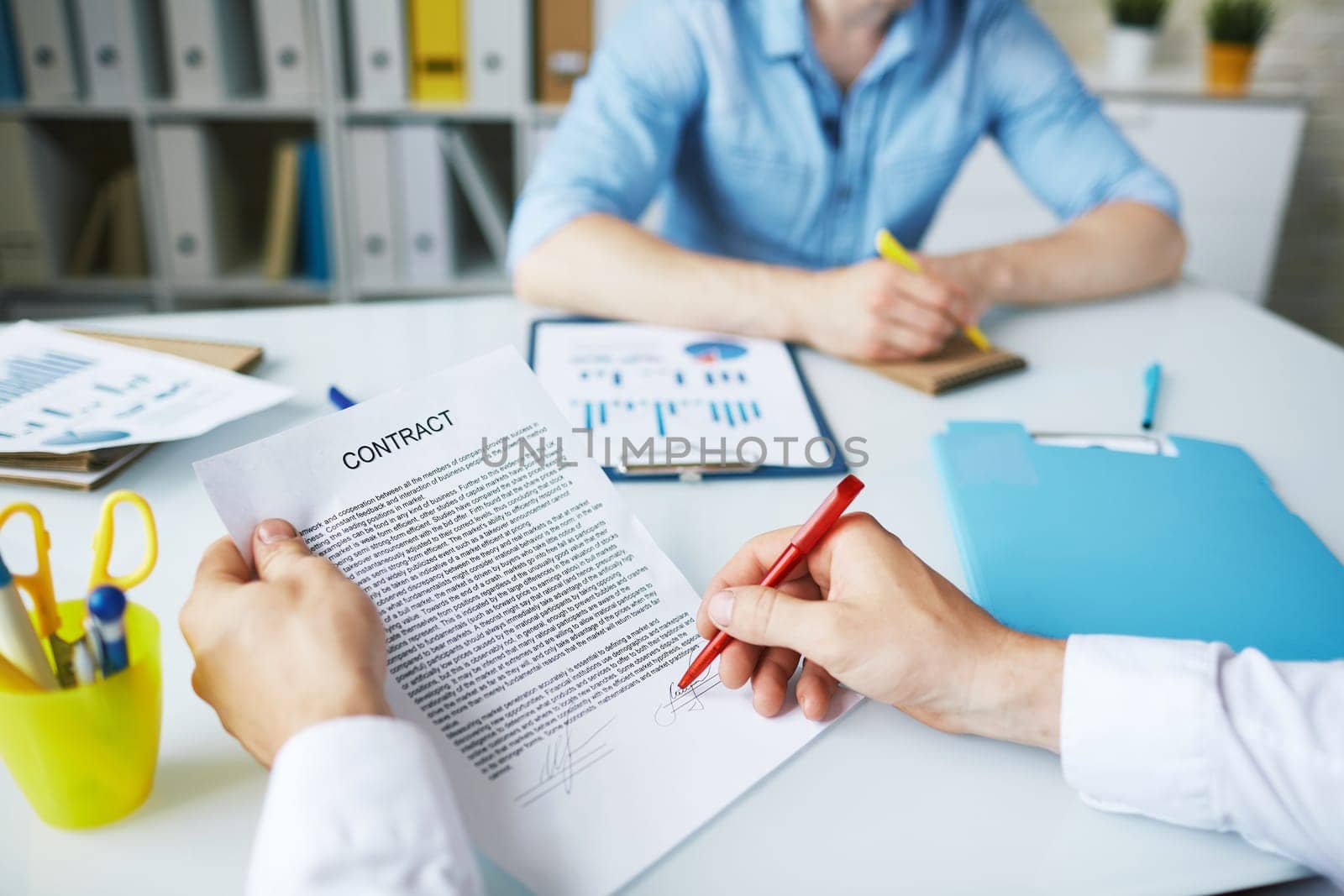 Businessman signing contract in working environment