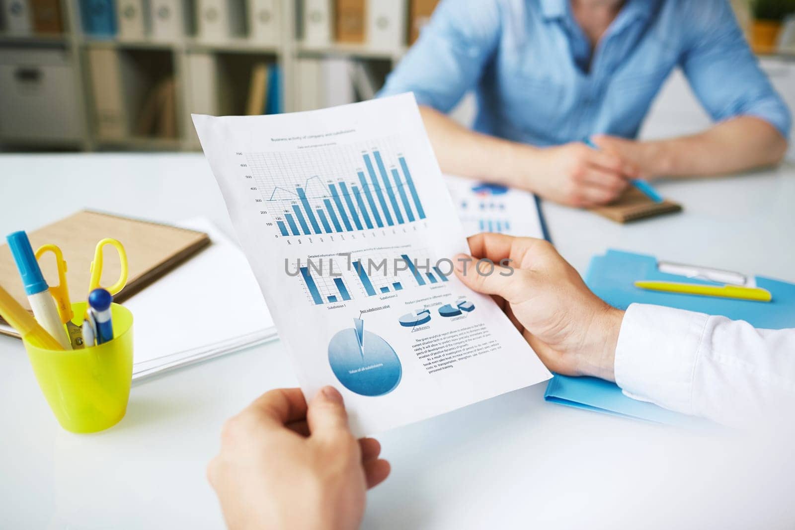 Businessman holding financial document over workplace