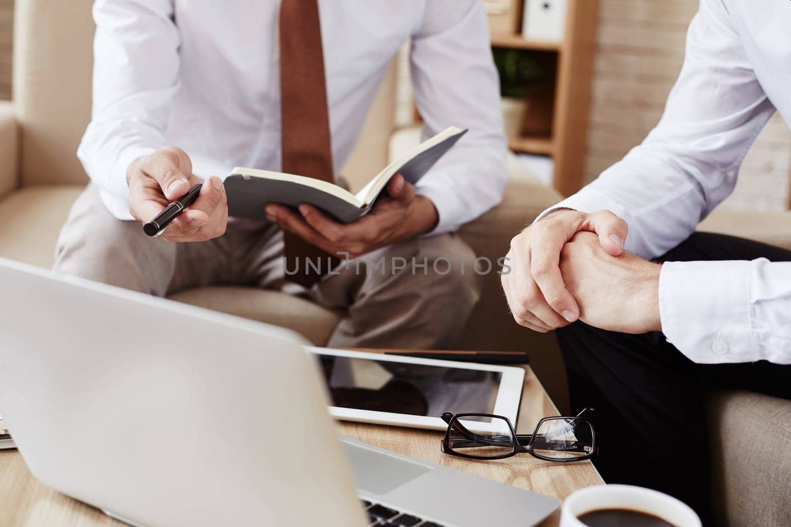Male employee pointing at laptop while explaining data at meeting