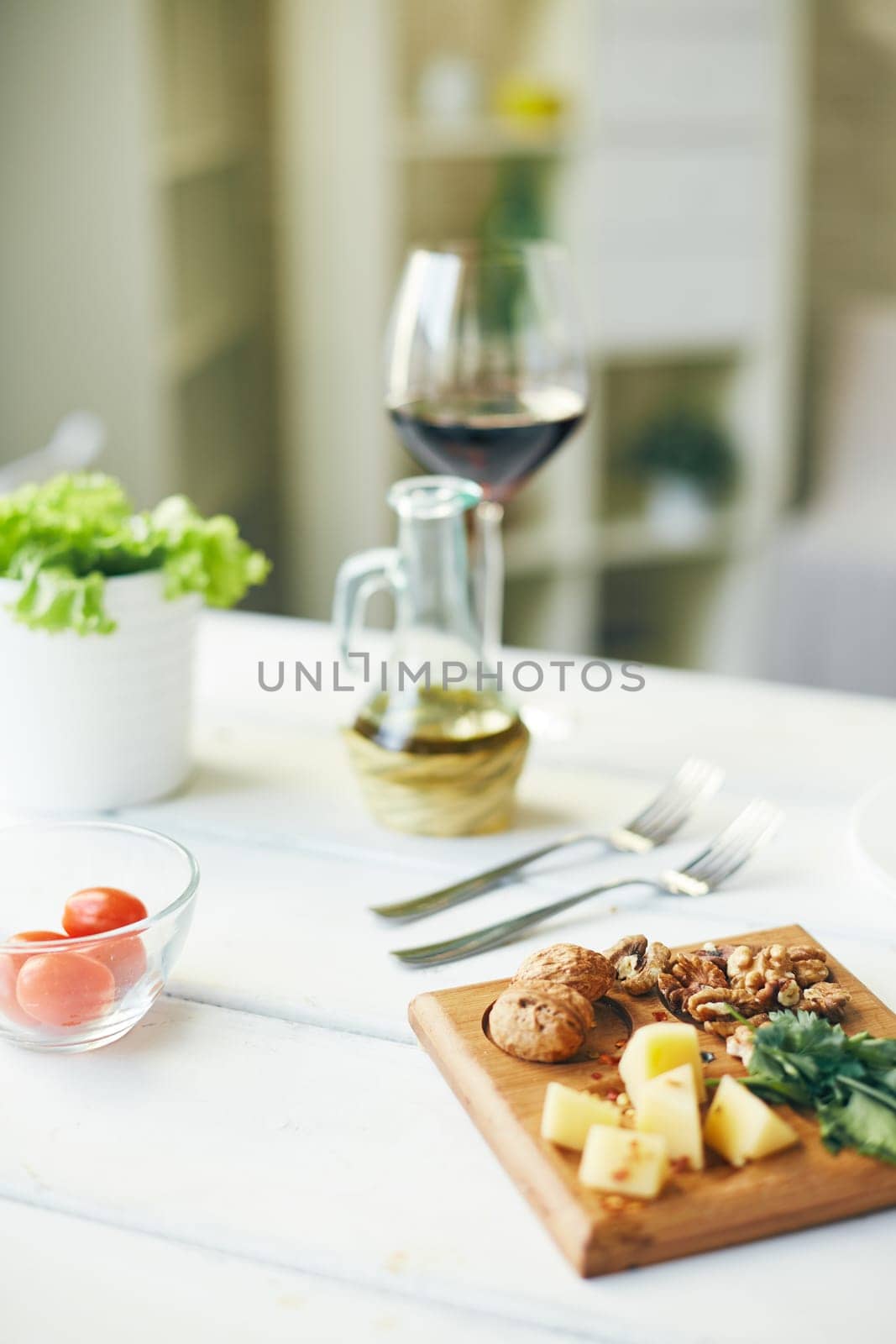 Walnuts, cheese and green parsley on wooden utensil and other food on background
