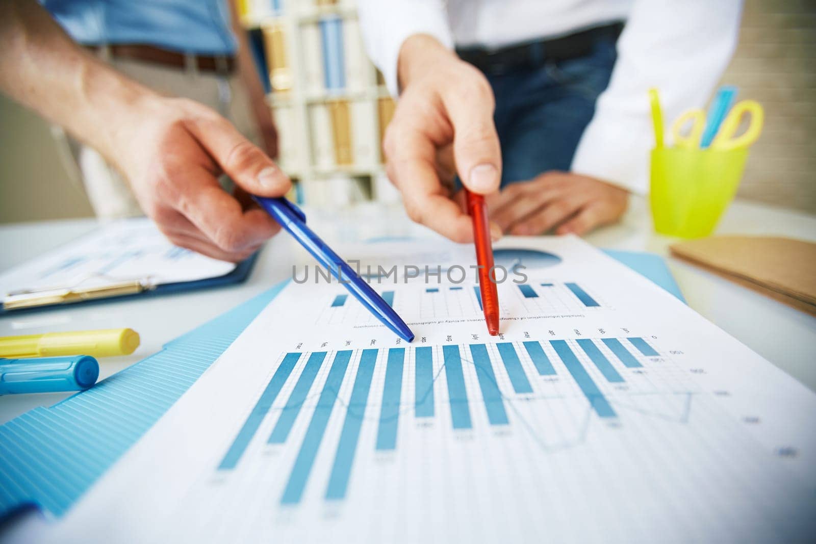 Two colleagues discussing business document at meeting