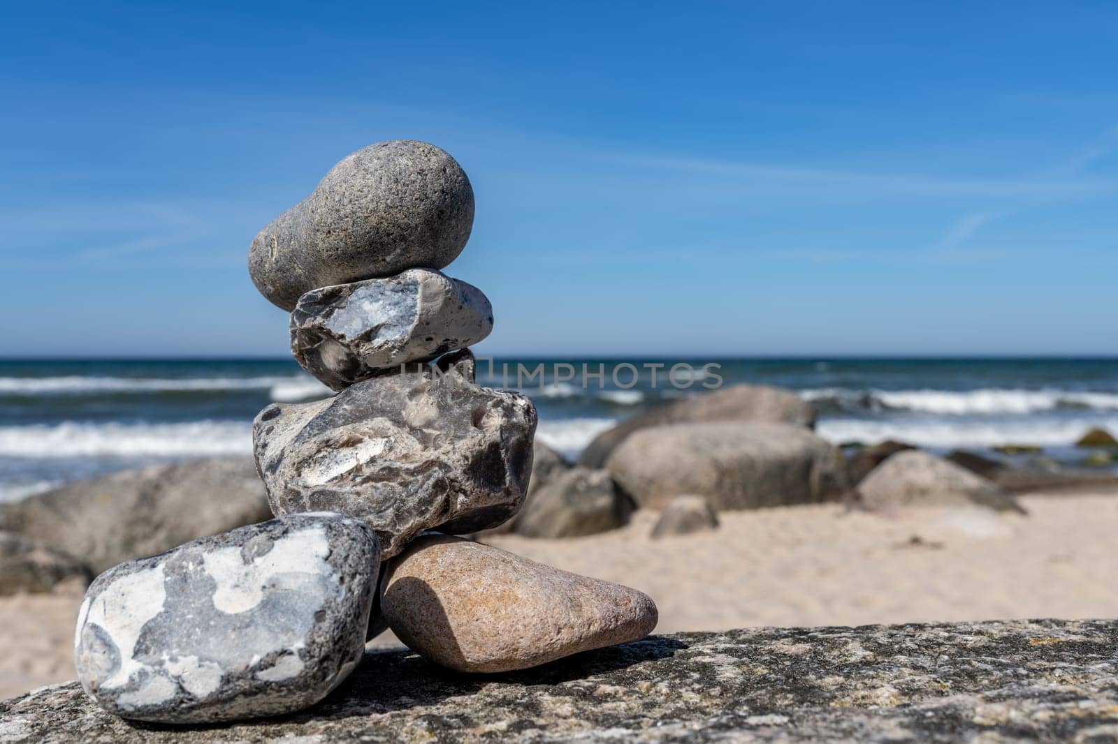 Stone pyramids on the dreamy Baltic Sea sandy beach on Rügen to the spectacular orange sunset