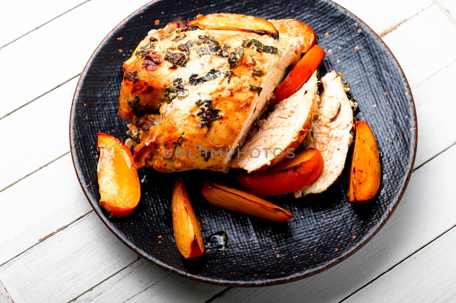Chicken fillet fried with persimmons on the plate. Healthy food