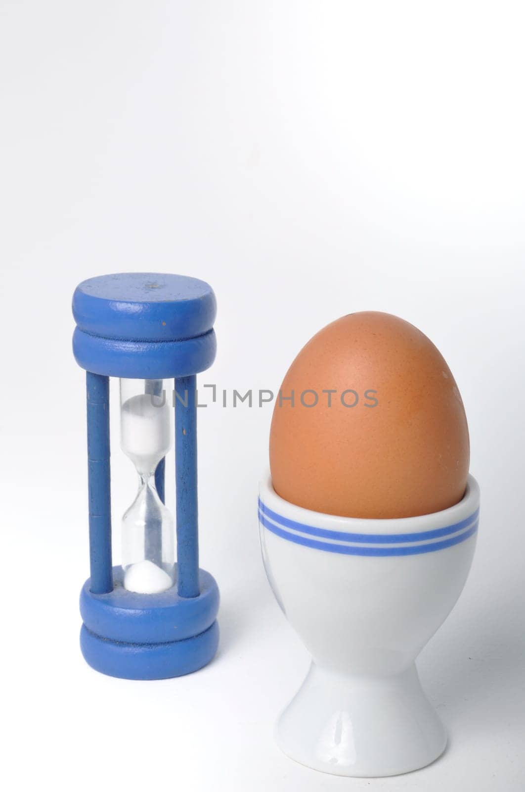 Boiled egg and hourglass on a white background