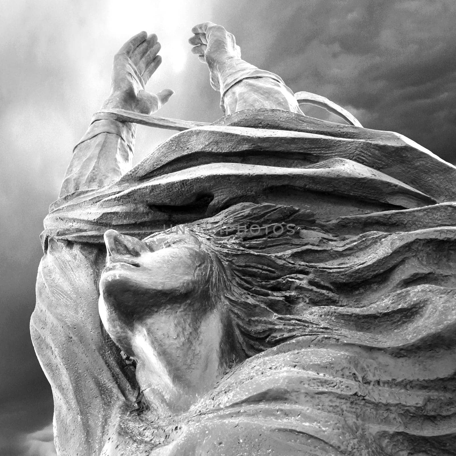 Statue of a woman with arms outstretched upwards. Peace, freedom, Easter concept and more.